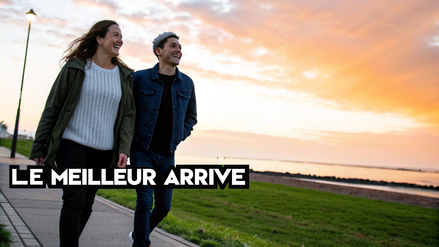 Un couple souriant marche le long d'un sentier au coucher du soleil, au bord de l'eau, avec le texte "Le meilleur arrive" en surimpression.