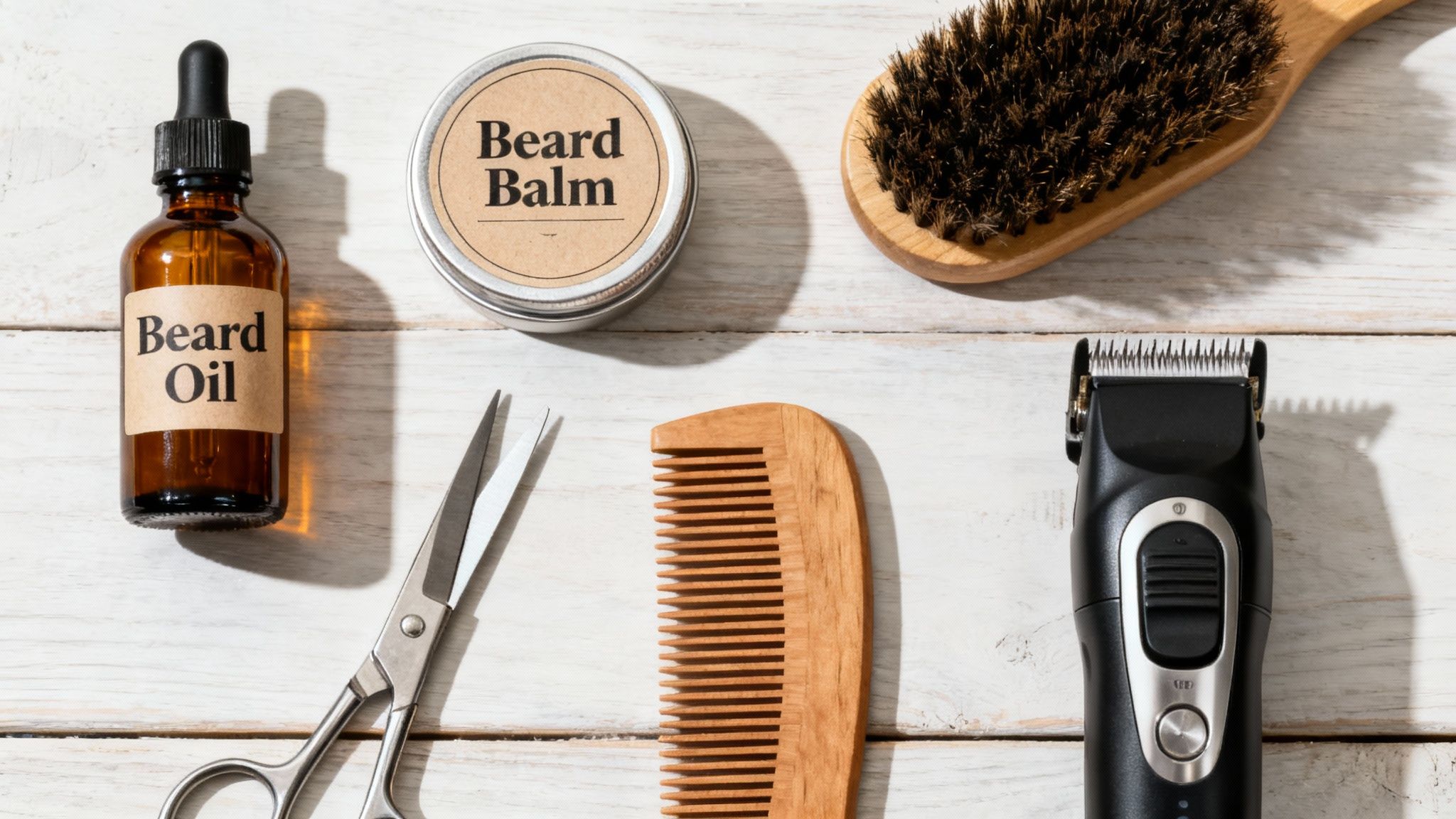 A flat lay of beard grooming tools including oil, balm, brush, comb, scissors, and trimmer.