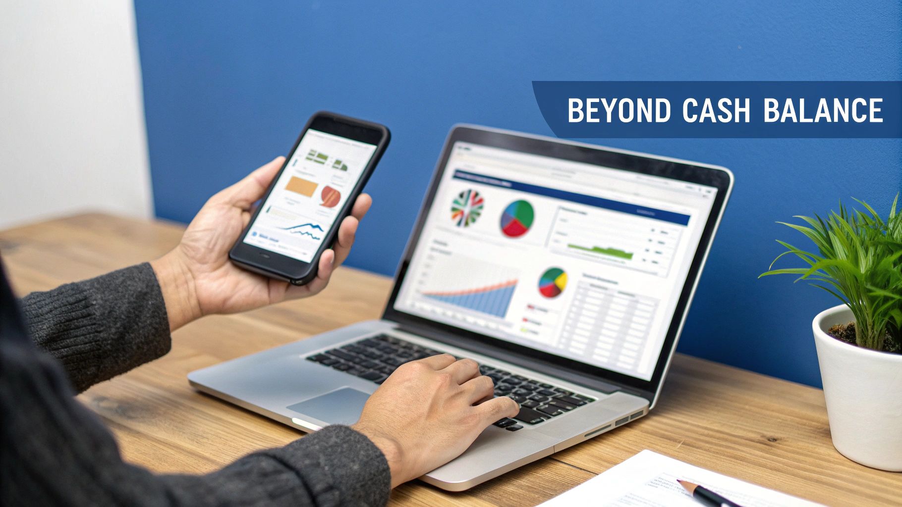 A person views business analytics dashboards on a laptop and smartphone, showcasing data visualizations like pie charts and bar graphs.