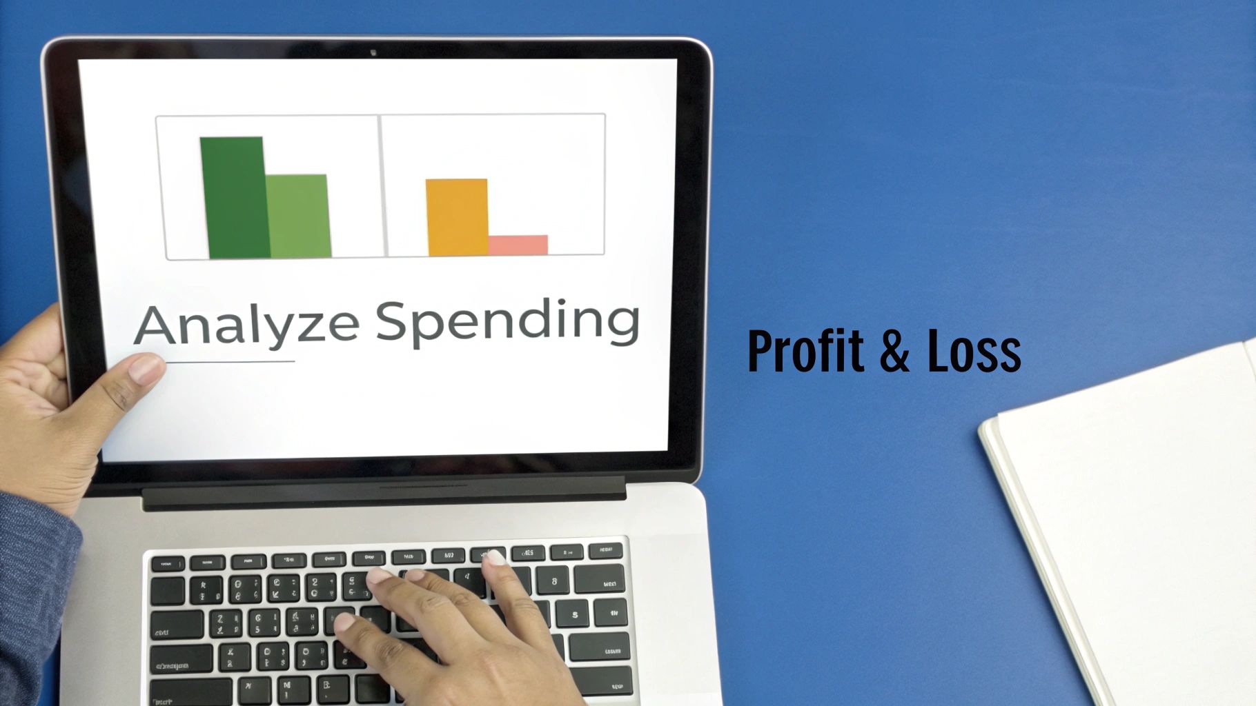 Hands using a laptop displaying a 'Analyze Spending' bar chart, with 'Profit & Loss' text on a blue desk.