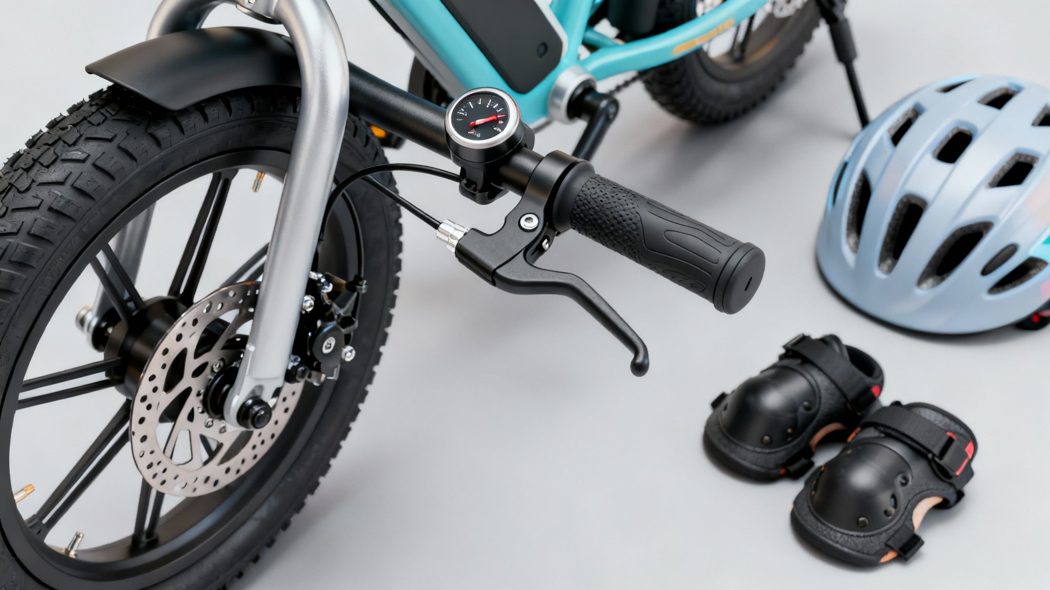 אופניים חשמליים לילדים בצבע תכלת עם גלגל קדמי, בלם דיסק, כידון, קסדה ומגני ברכיים על רקע בהיר.