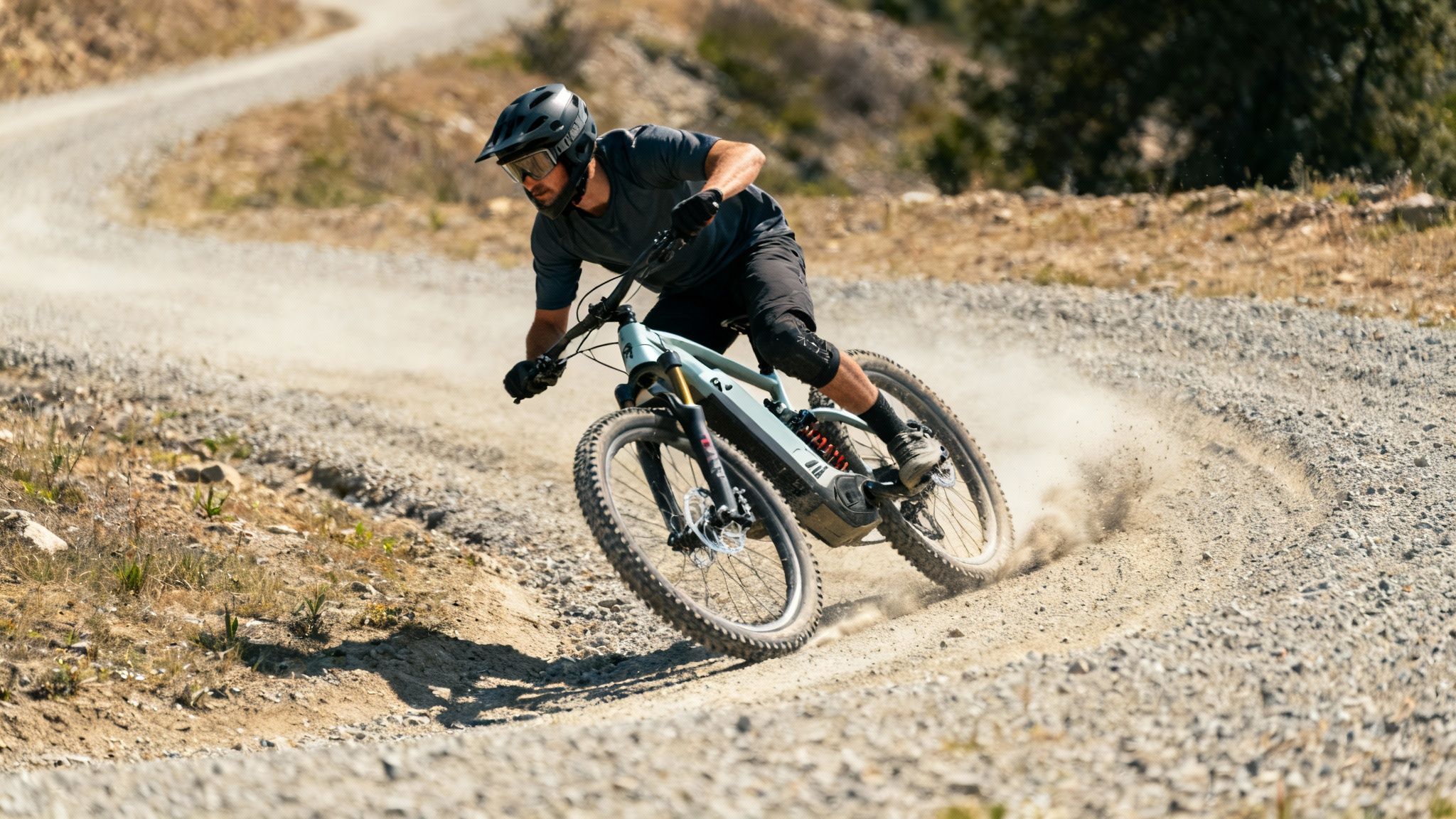 גבר רוכב באגרסיביות על אופניים חשמליים בדרך עפר הררית, מרים אבק בסיבוב.