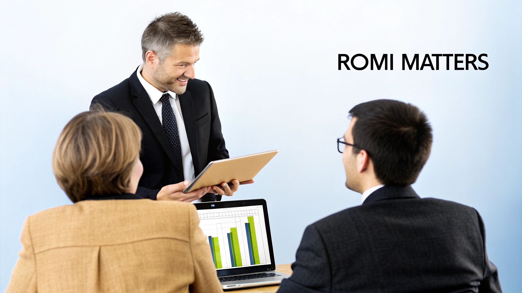 Three business people discuss charts on a tablet and laptop, focusing on measuring return on marketing investment.