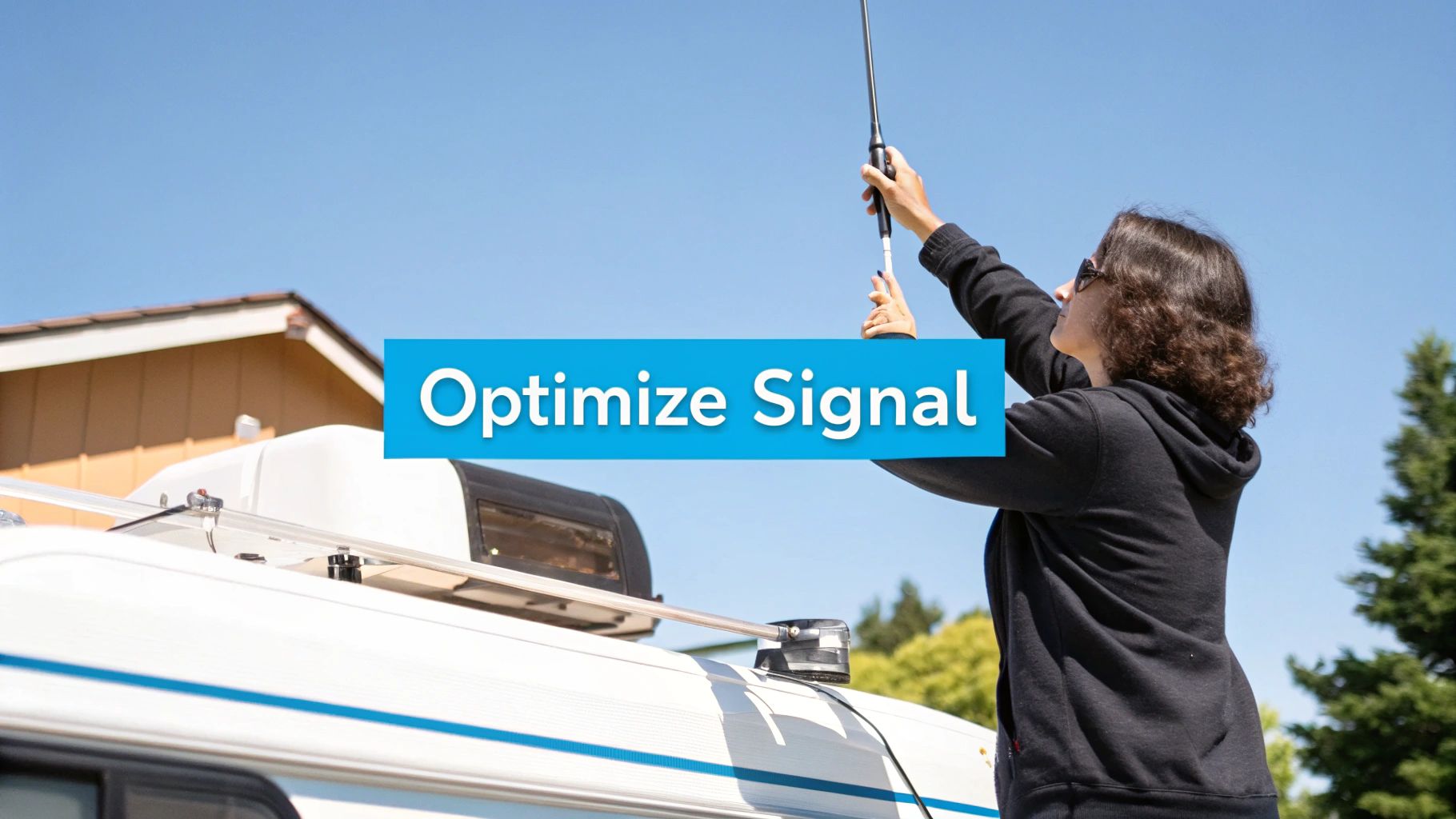 A person adjusting a cellular antenna on top of an RV, with a scenic background.