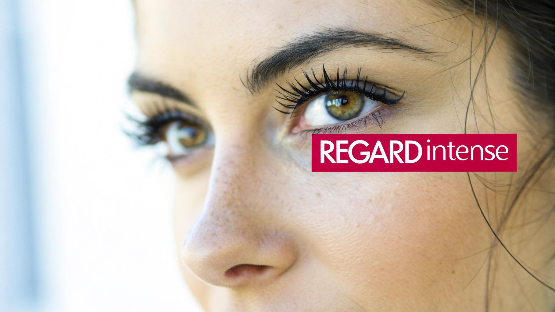 Gros plan sur les yeux d'une femme avec des cils intenses et le texte rouge "REGARD intense".