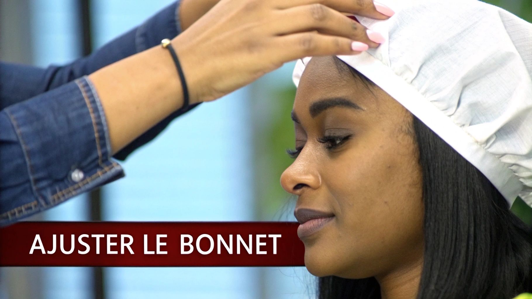 Une femme ajuste méticuleusement son bonnet pour perruque devant un miroir.