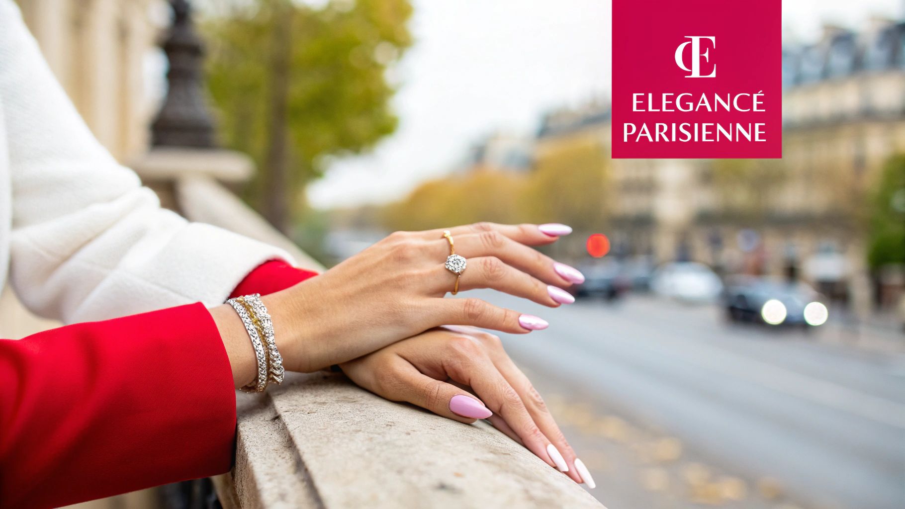 Mains d'une femme avec bague, bracelets et ongles roses, sur un parapet à Paris.
