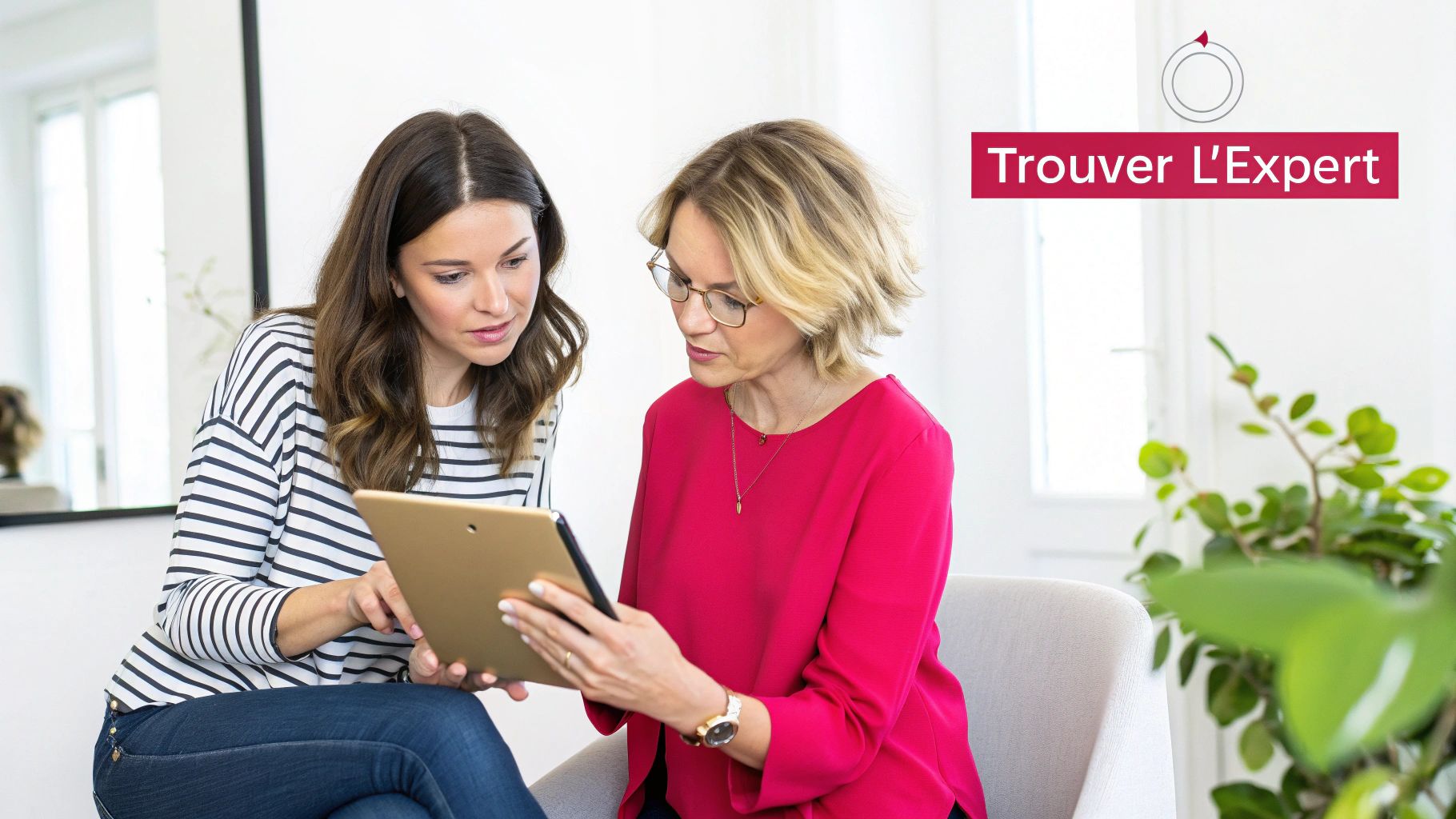 Deux femmes, une plus jeune et une plus âgée, consultent ensemble une tablette dans un intérieur moderne et lumineux.