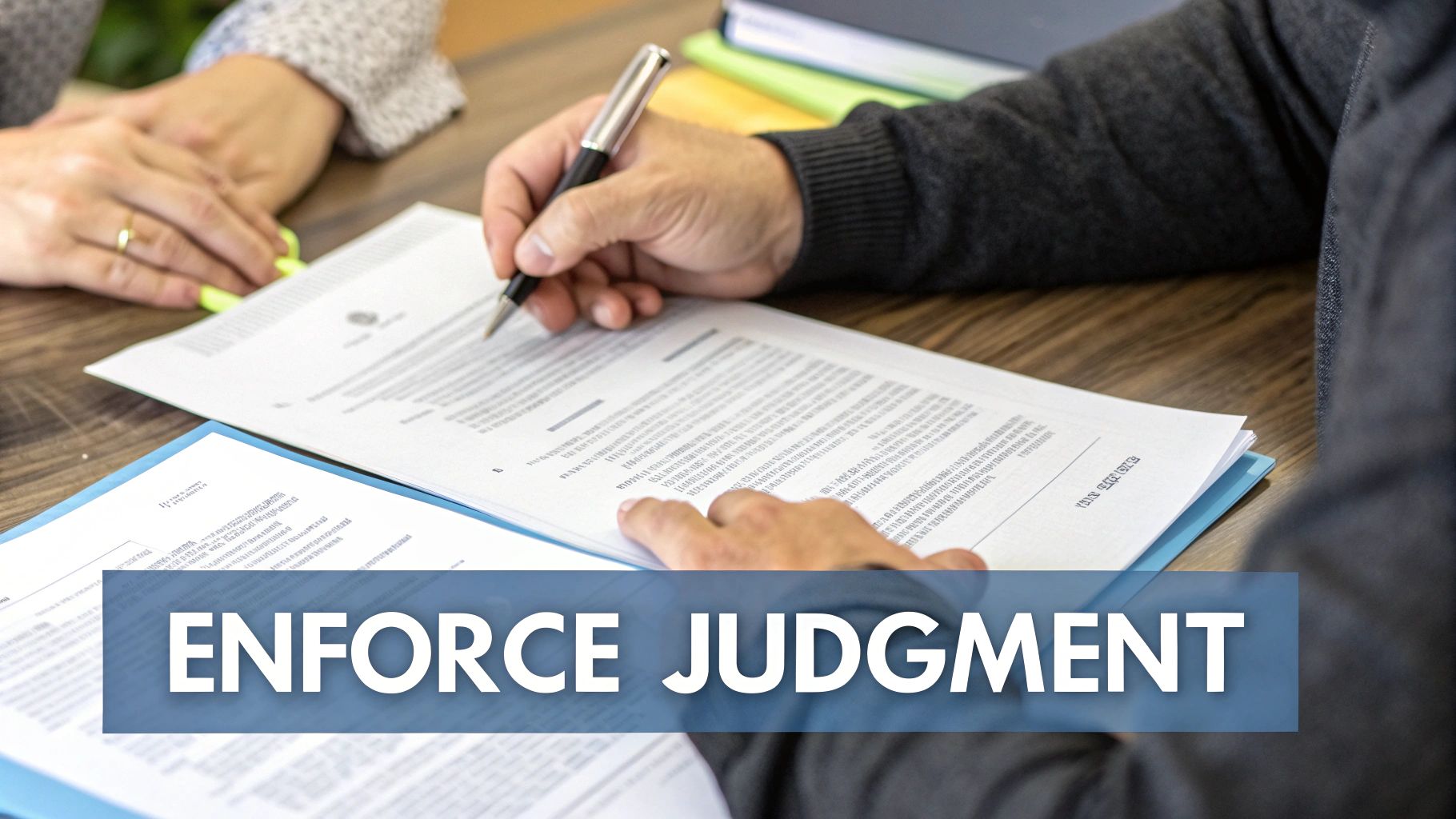 Two individuals at a table, one signing legal documents, representing the process of judgment enforcement.