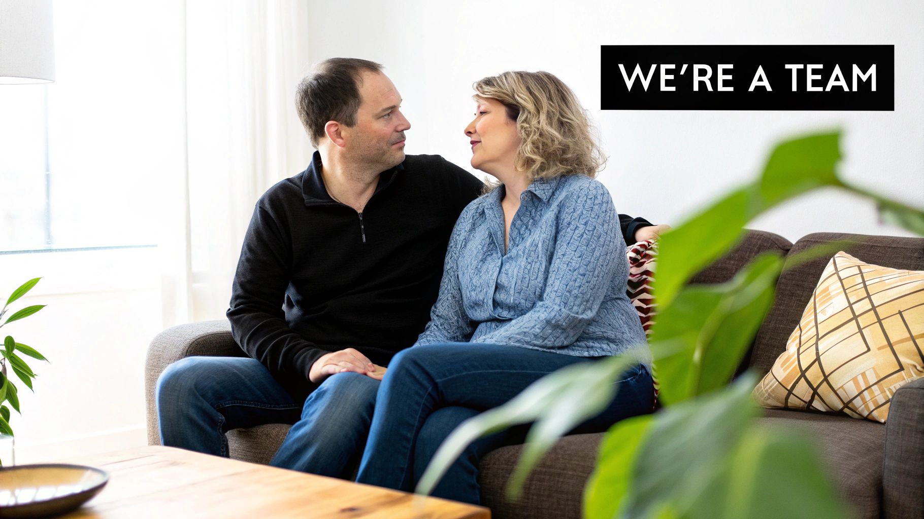 A couple sits closely on a couch, looking at each other, with text overlay 