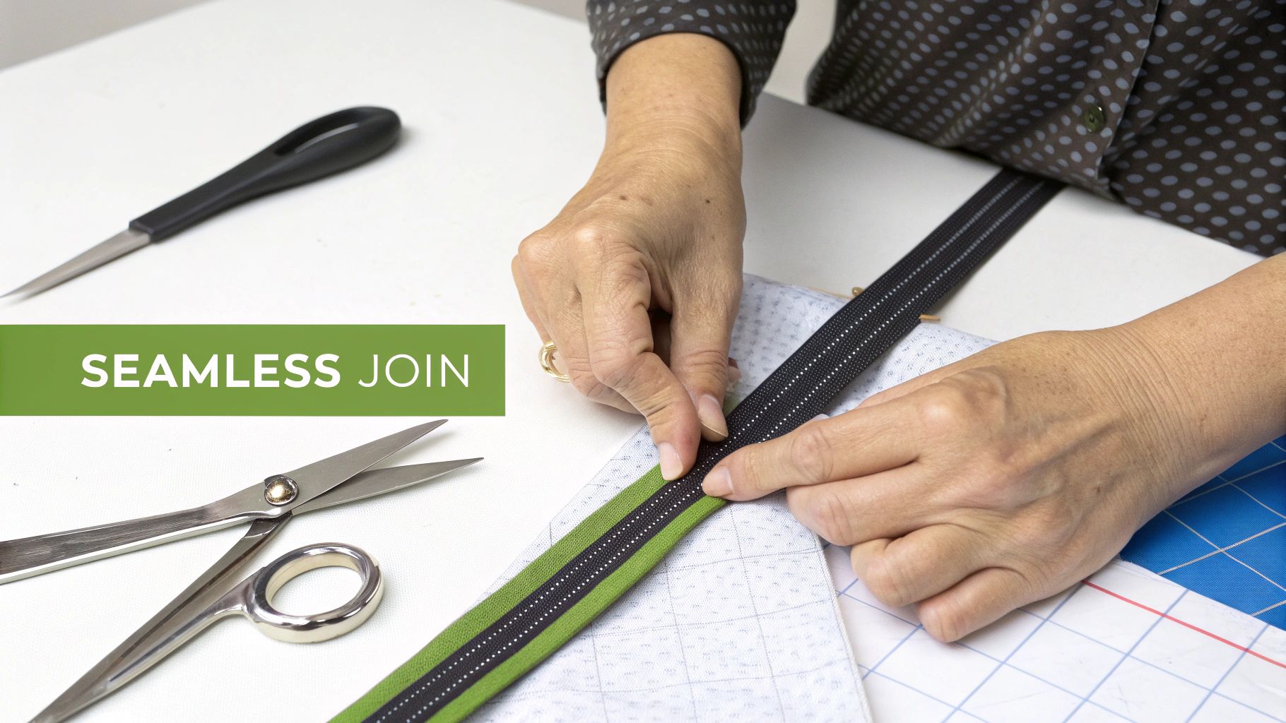 Hands attaching a green and black binding tape, ensuring a seamless join in sewing.