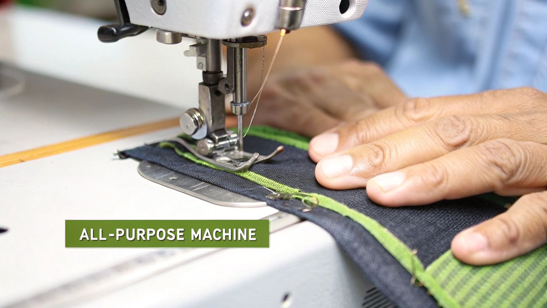 Close-up of hands guiding dark fabric with bright green trim under a sewing machine needle.