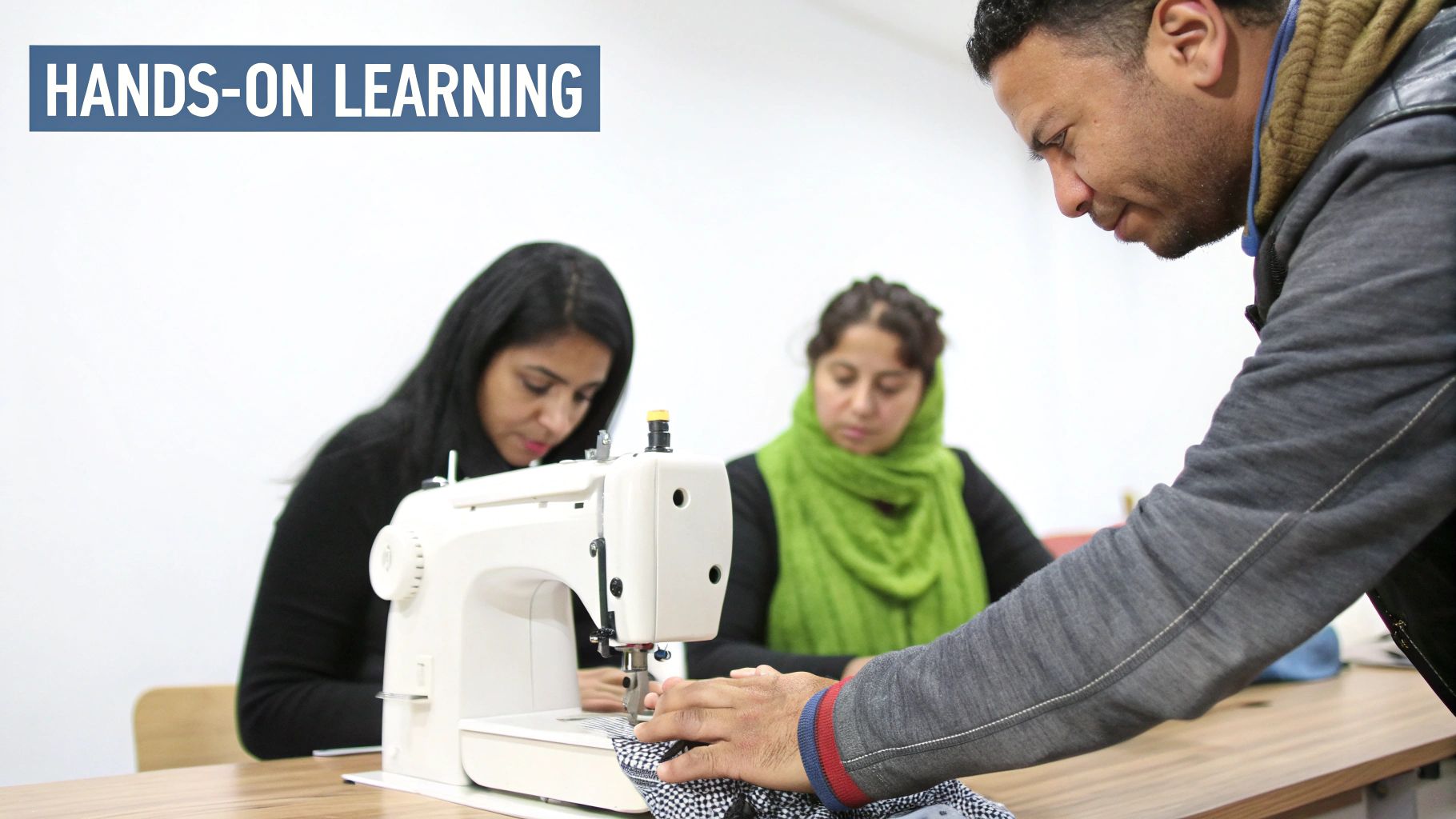 Three adults, two women and a man, engaged in hands-on learning with sewing machines.