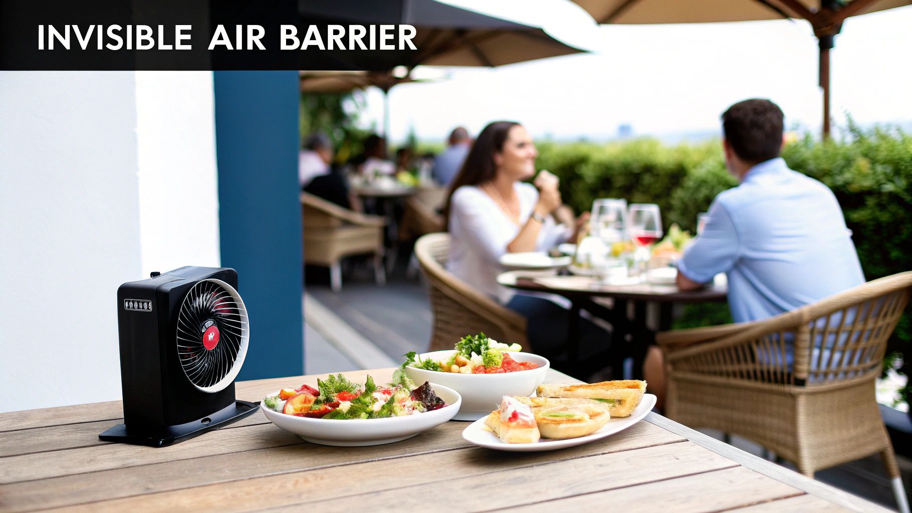 A black air barrier device on a wooden table with food plates at an outdoor restaurant.