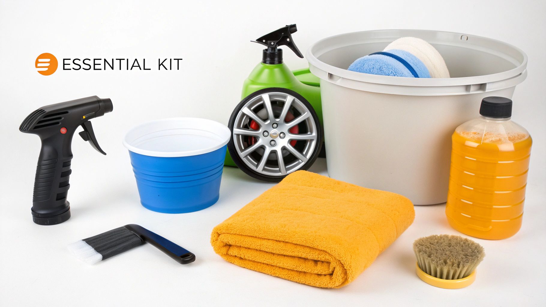 An essential car detailing kit displayed on a white surface, featuring a spray gun, buckets, towels, and cleaning brushes.