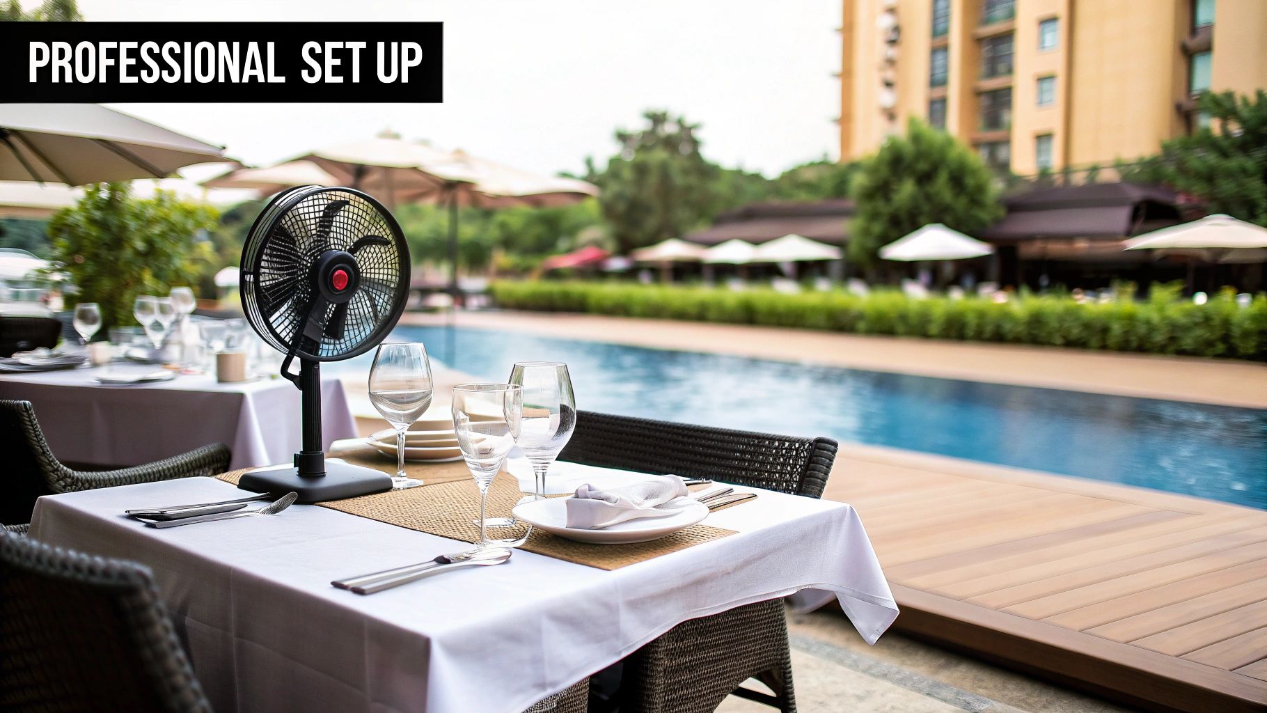 Professional outdoor dining setup by a swimming pool with tables, chairs, and a portable fan.
