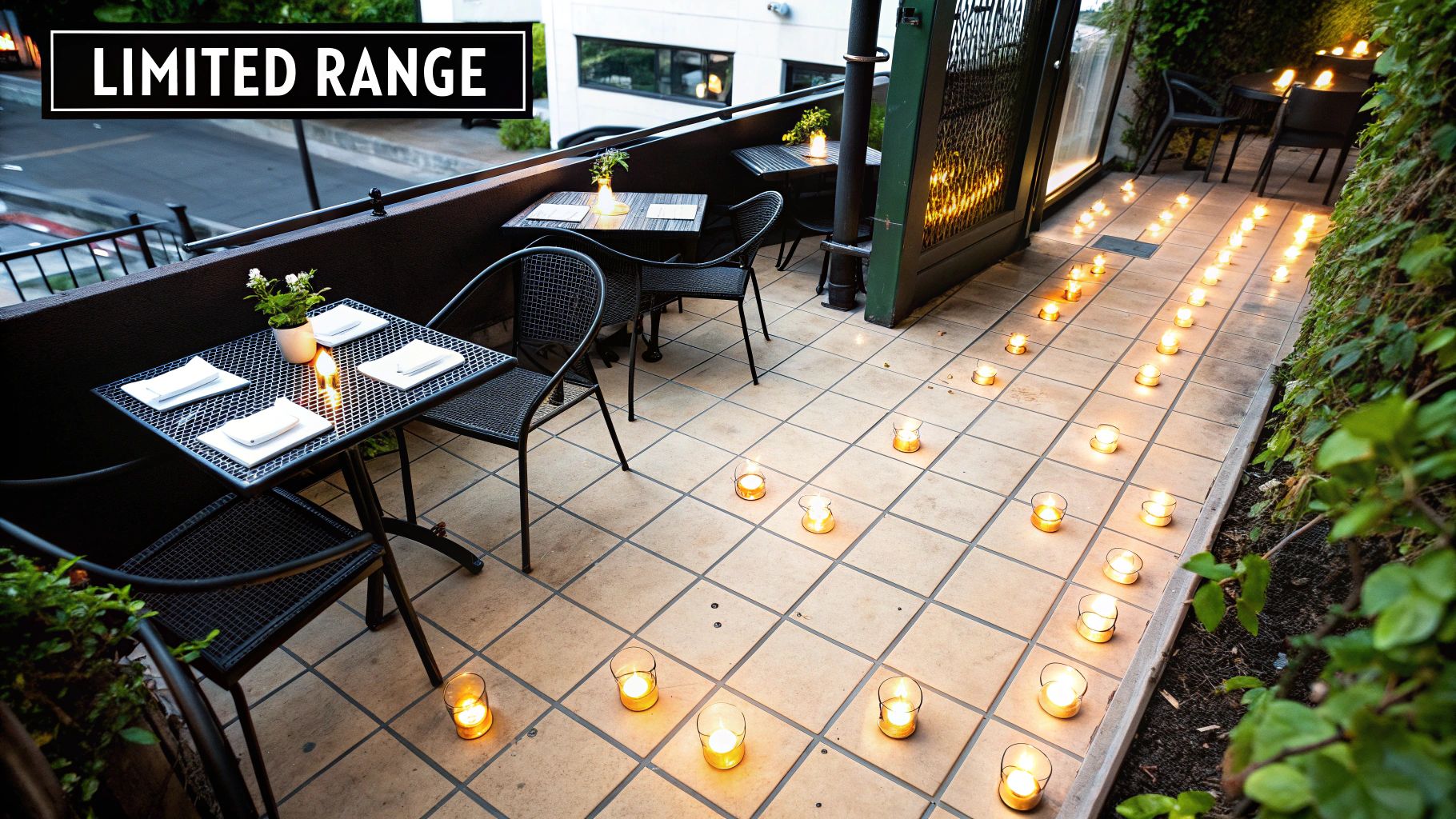 Cozy outdoor restaurant patio at night with tables, chairs, and many flickering candles.