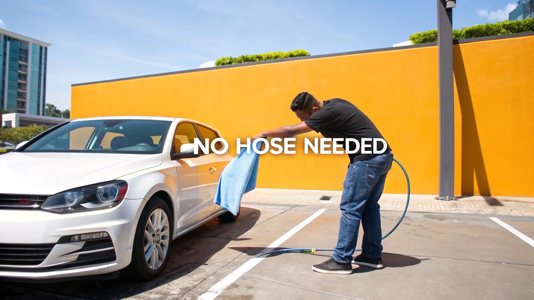 A person cleans a white car with a blue cloth, highlighting a waterless wash.