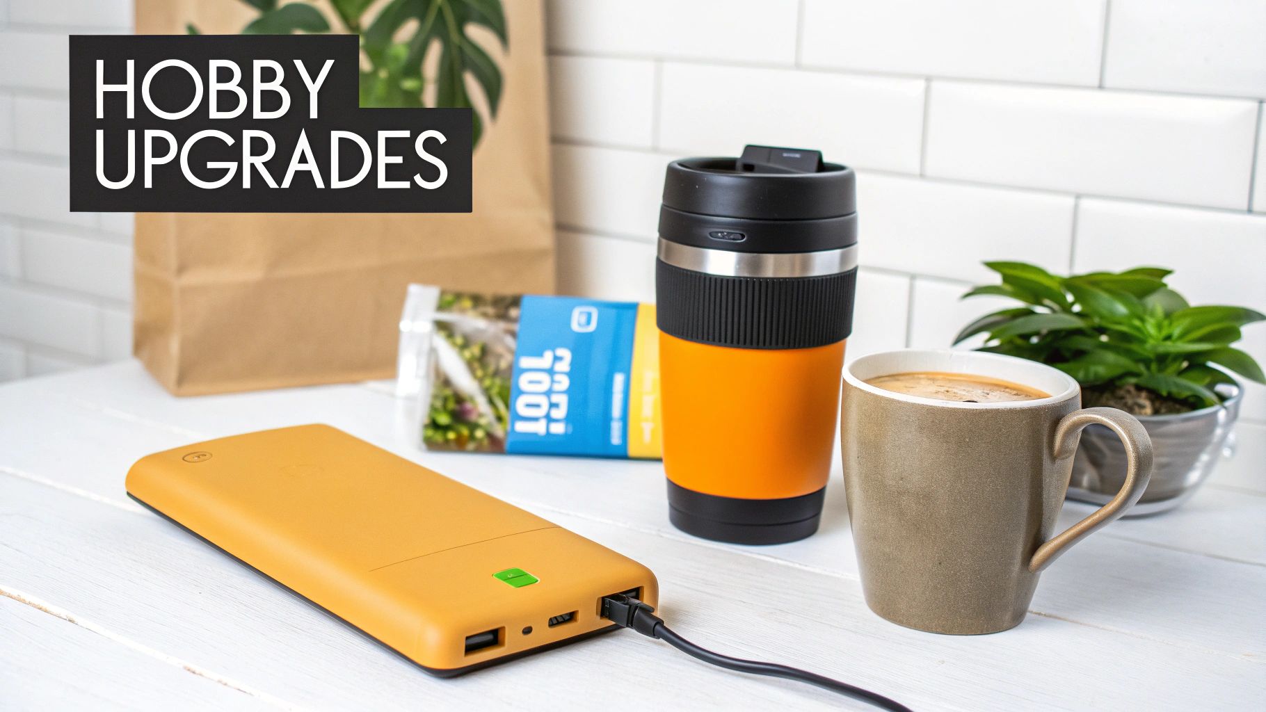 A collection of hobby upgrades including an orange power bank, travel mug, coffee, and plant.