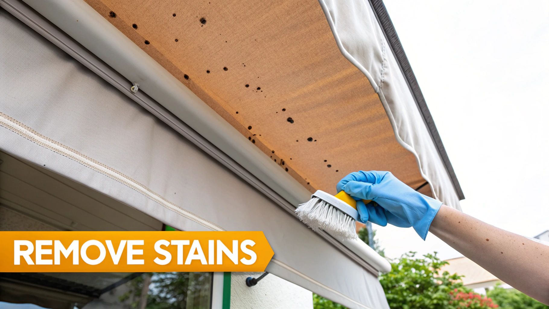 Close-up of a hand in a glove scrubbing a stubborn mildew spot on an RV awning.