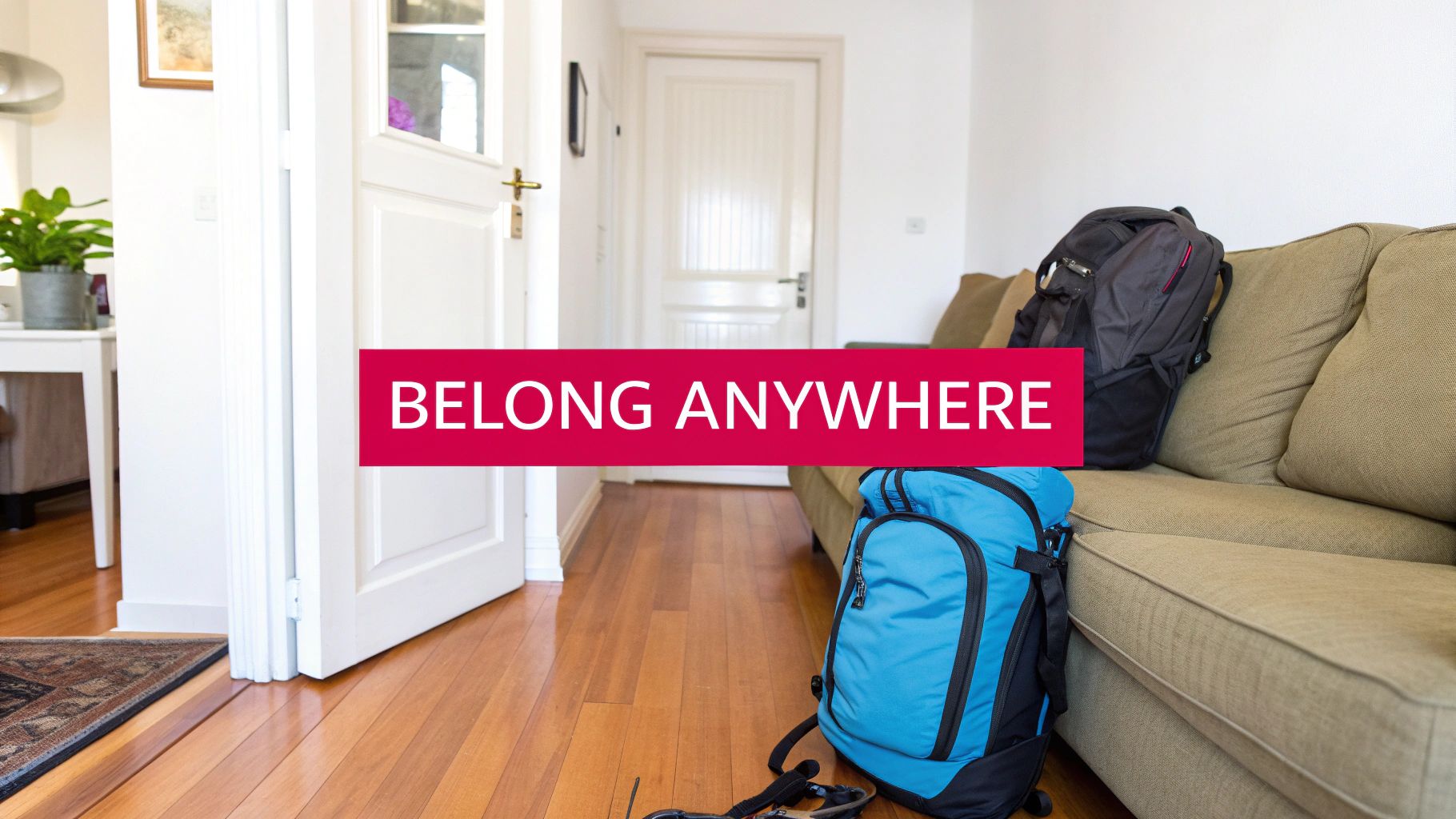 Two travel backpacks sit on a wooden floor next to a couch, with the text 'BELONG ANYWHERE'.