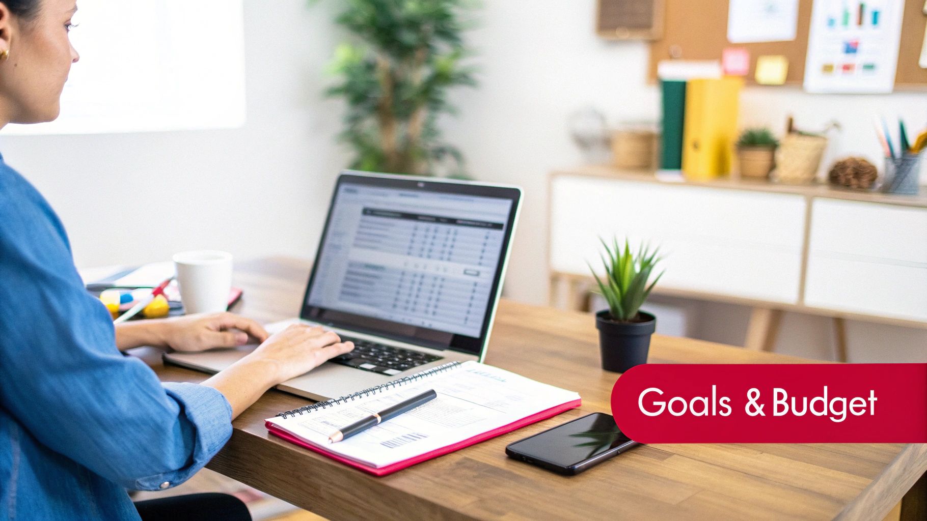A person writing on a notepad with a laptop and coffee nearby, signifying planning and goal setting.