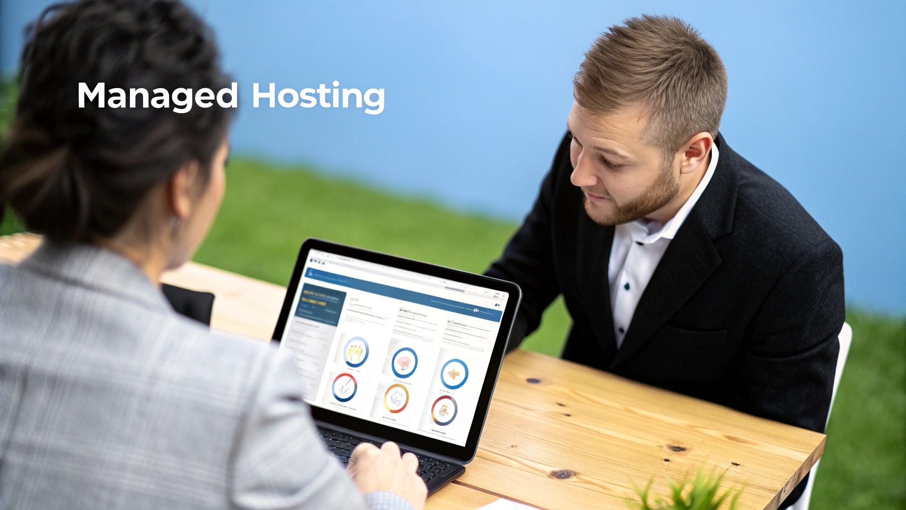 Man and woman collaborating on managed hosting solutions using a laptop outdoors.