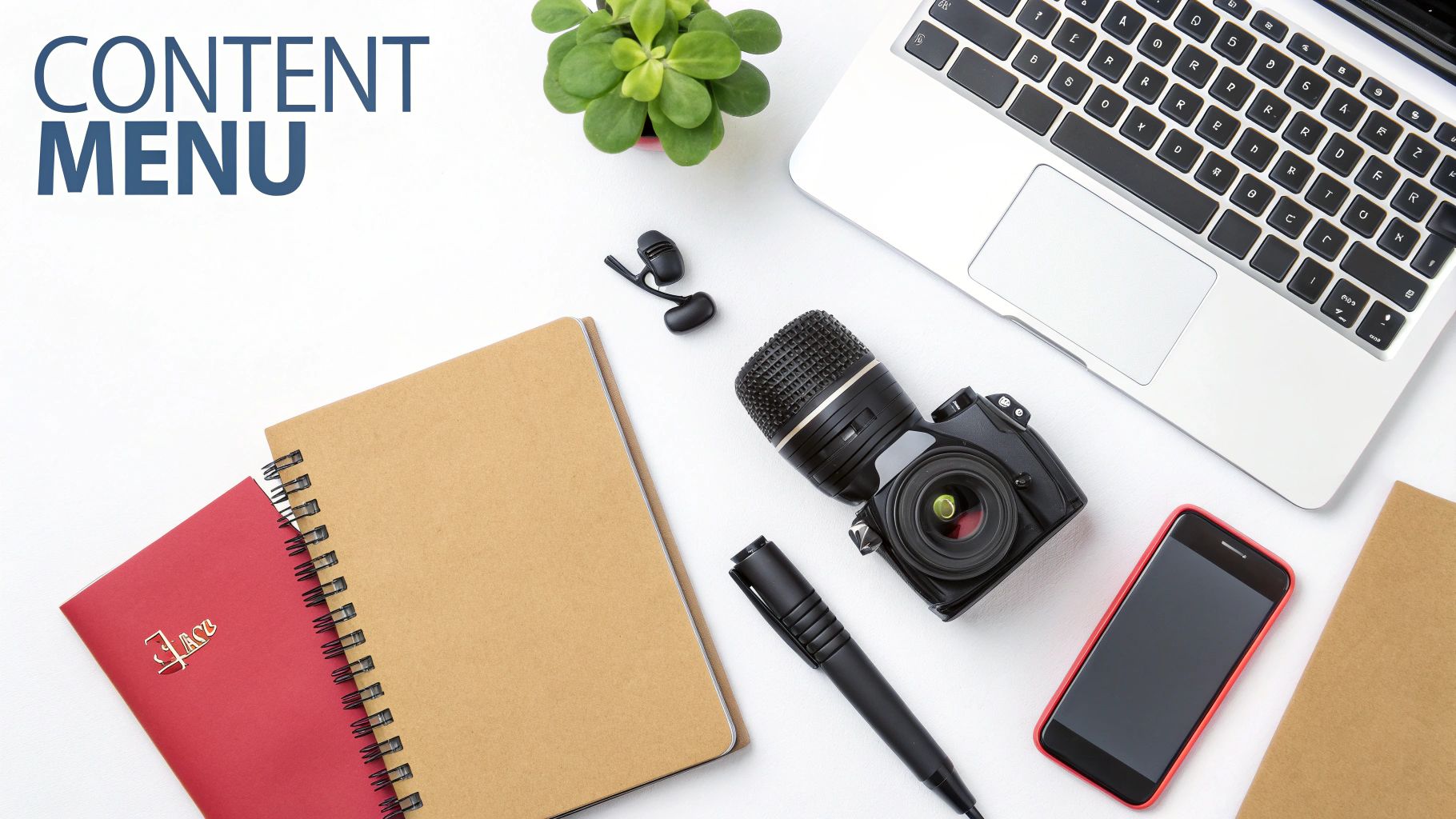 a surface with a notebook, laptop camera phone and pen on.