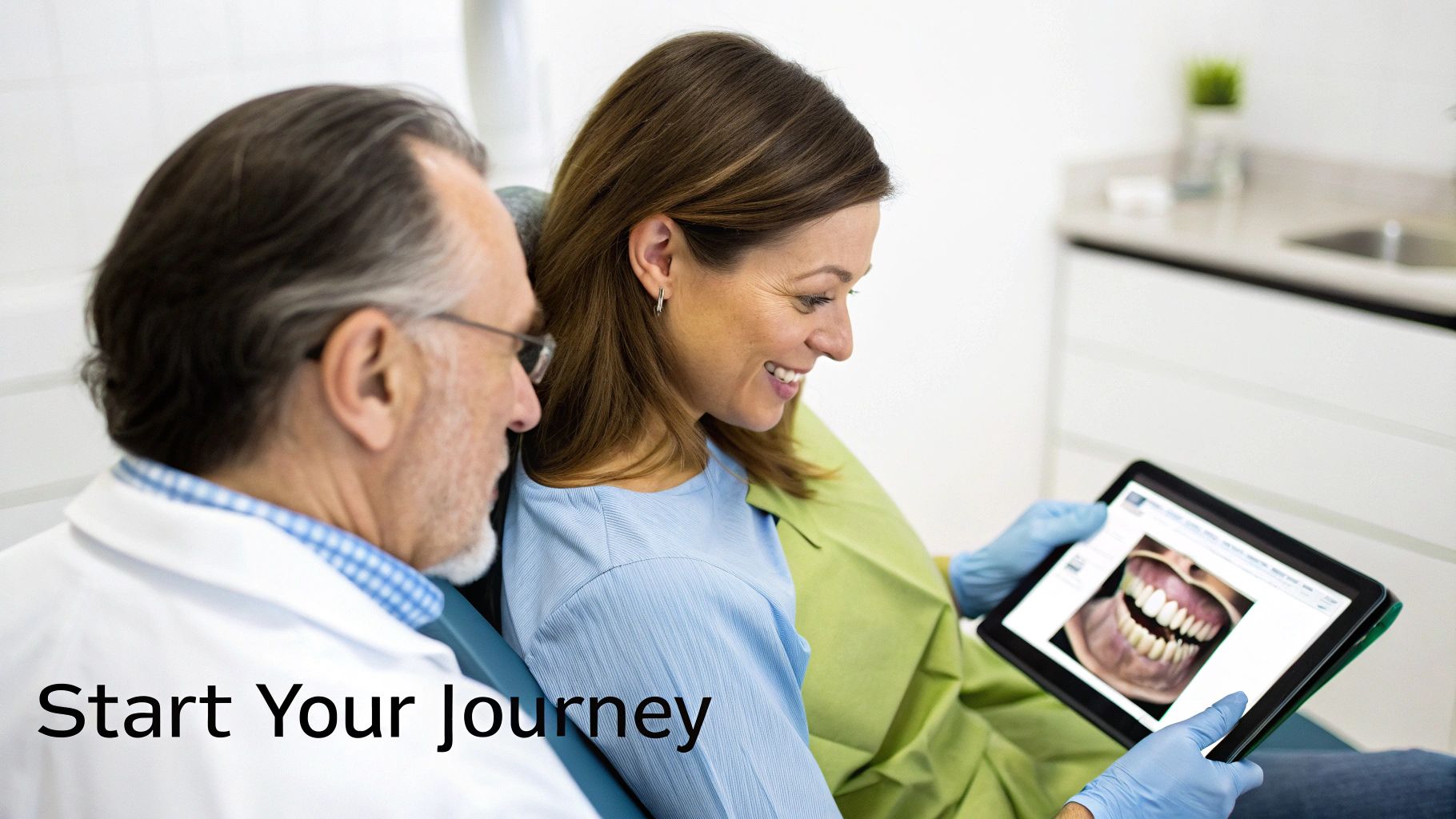 A prosthodontist explains dental work on a tablet to a smiling female patient during a consultation.