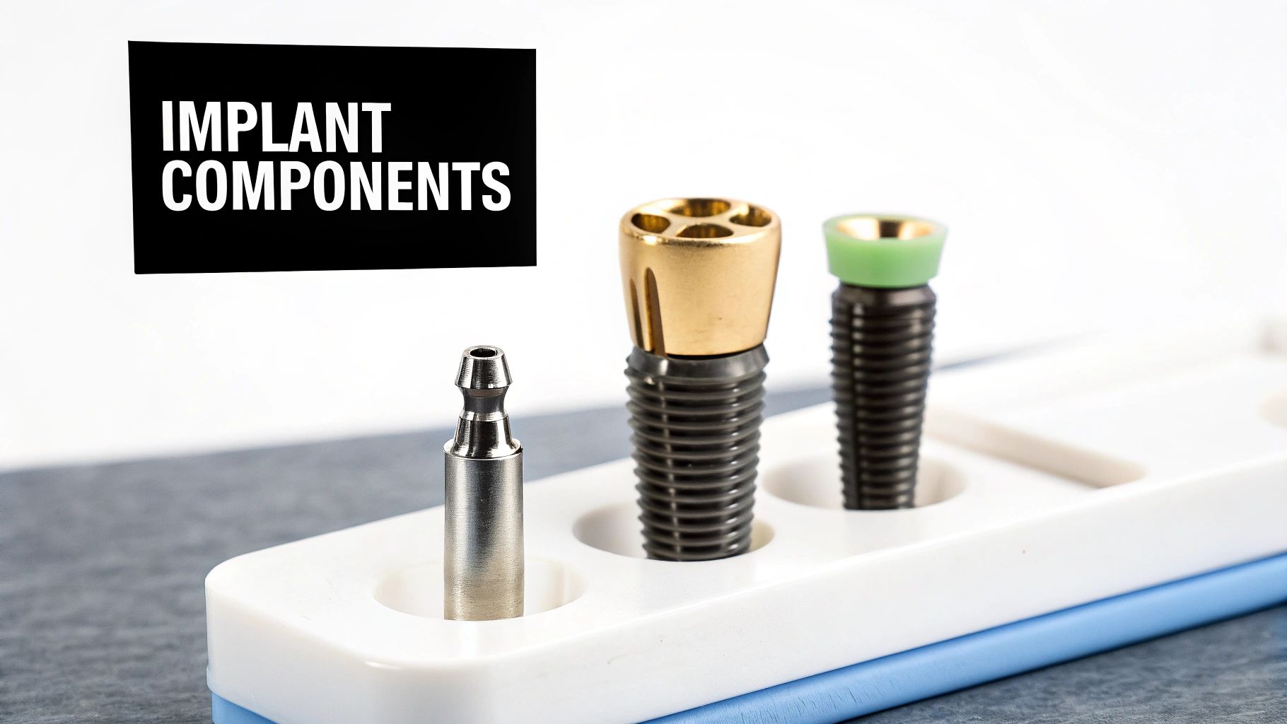 Close-up of various dental implant components displayed in a white organizer tray on a dark surface.