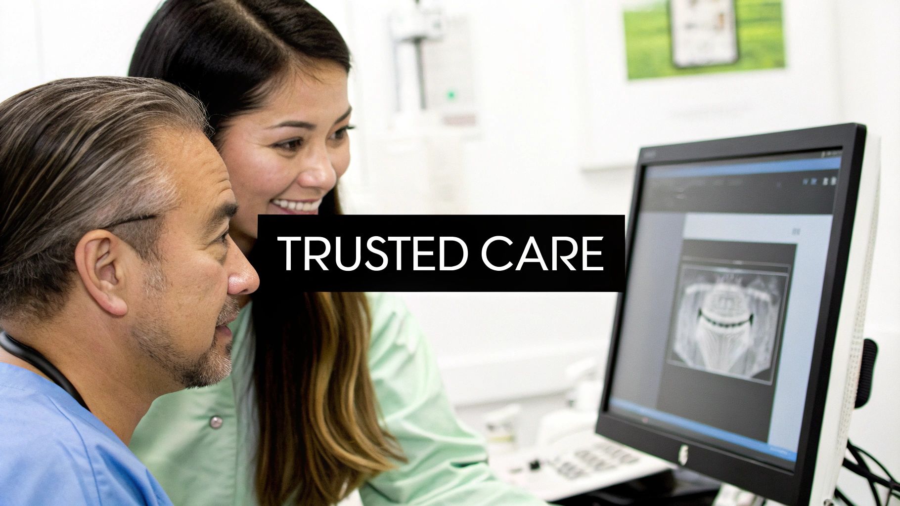 Two dental professionals, a man and a woman, review a dental X-ray on a monitor, symbolizing trusted care.