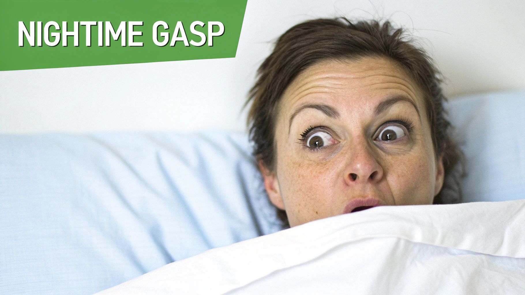 A woman with wide, startled eyes gasps from beneath a white blanket in bed.