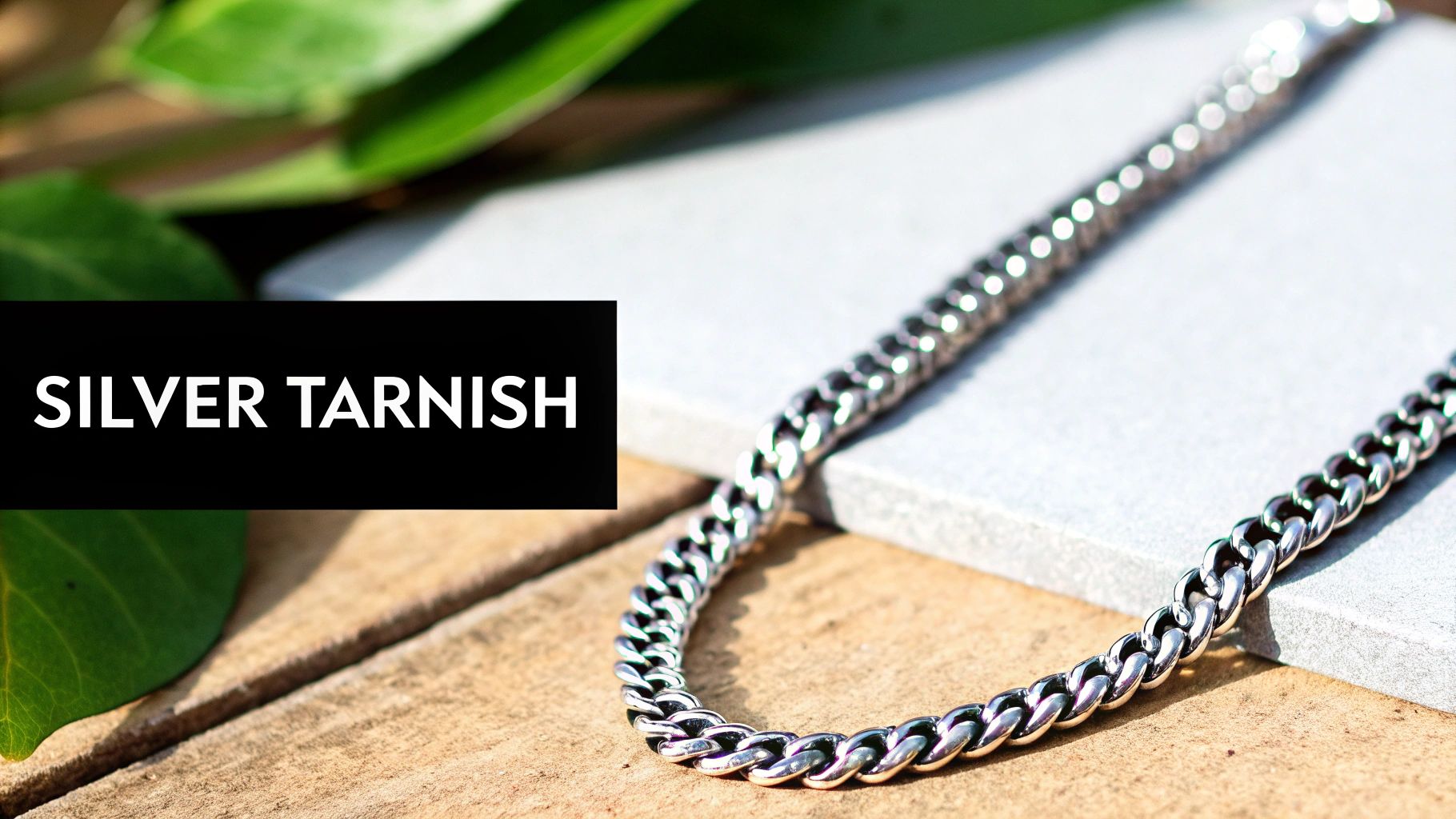 A close-up of a silver ring held between two fingers, showing its intricate design and shine.