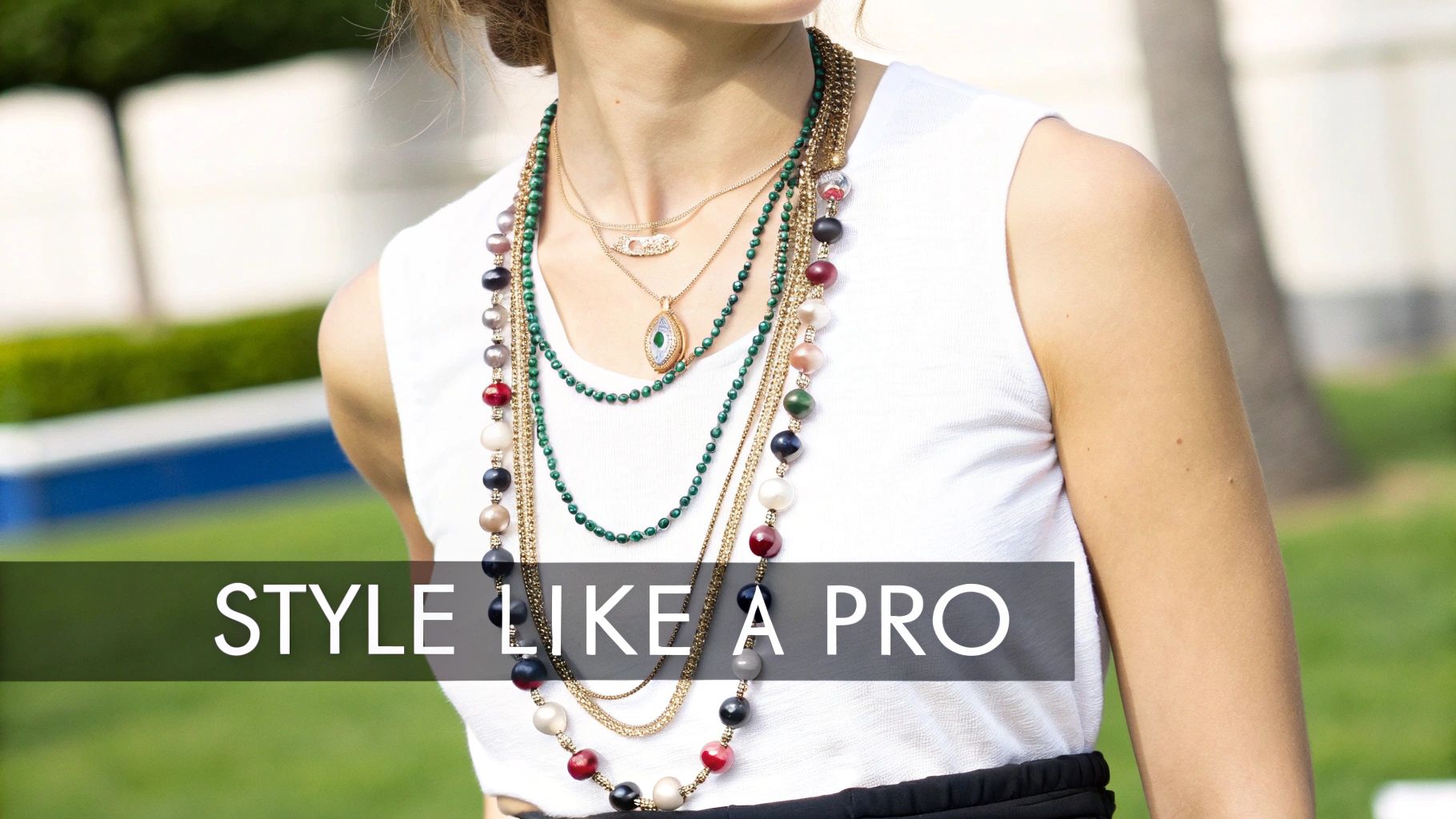 Close-up of a person wearing an array of layered necklaces featuring colorful beads and green gemstones.