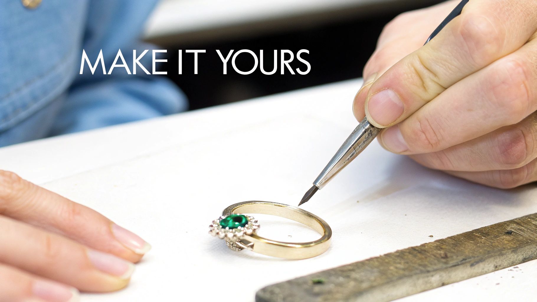 Hands customizing a beautiful gold ring with an emerald gemstone and small diamonds, symbolizing personalized jewelry.