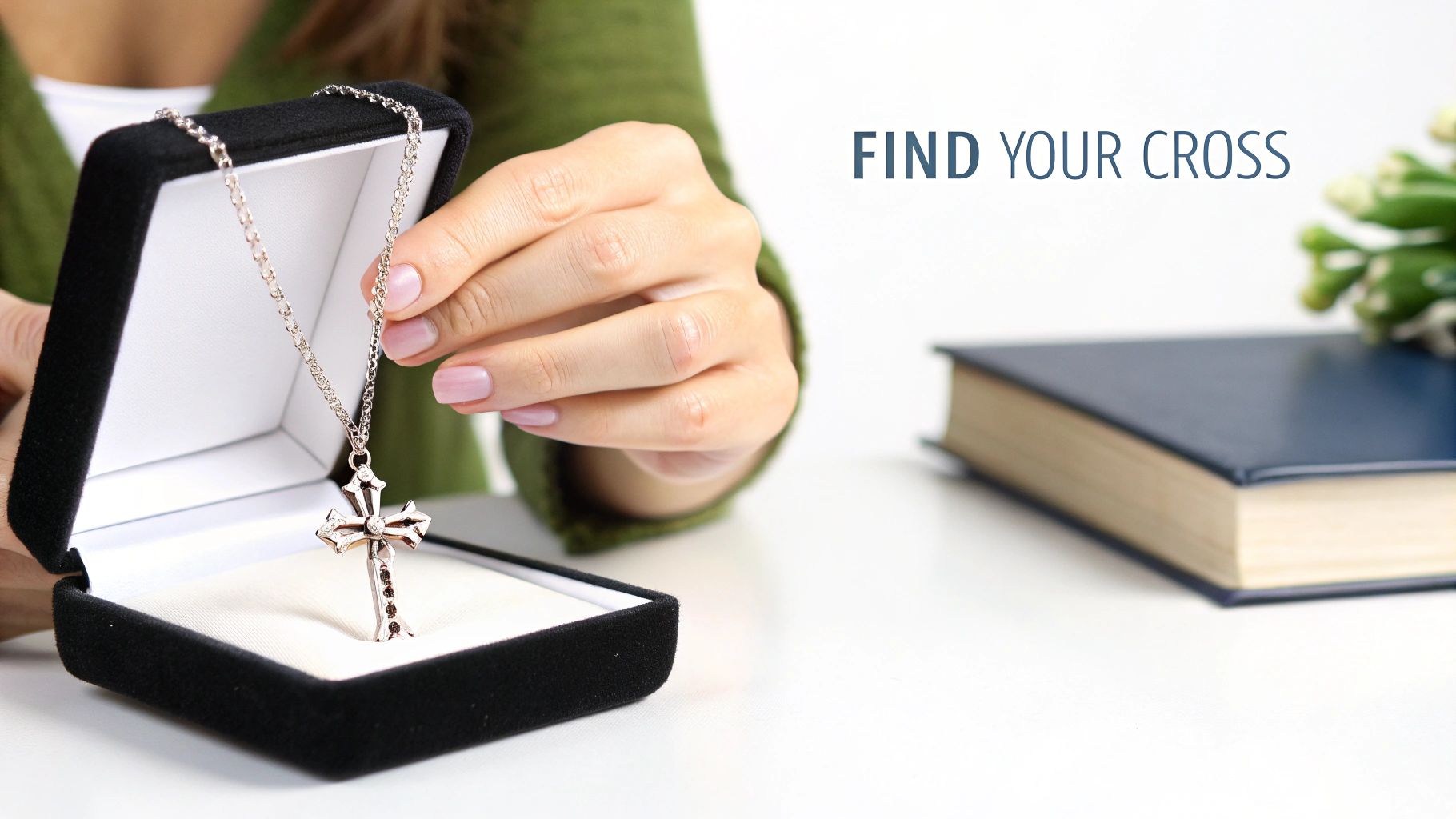 A person's hand holding a silver cross necklace with gems, taking it from a black jewelry box.