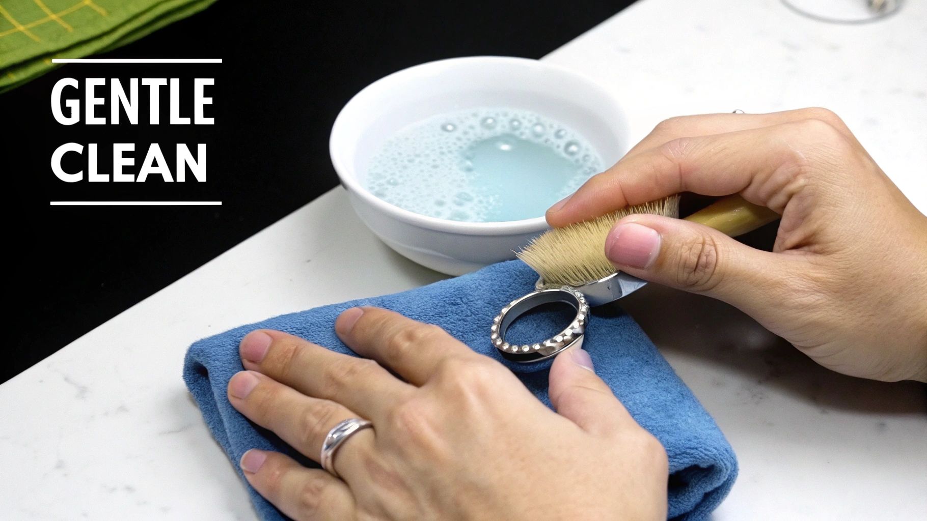 A bottle of cleaning solution next to a soft cloth, with silver jewelry laid out ready to be polished.