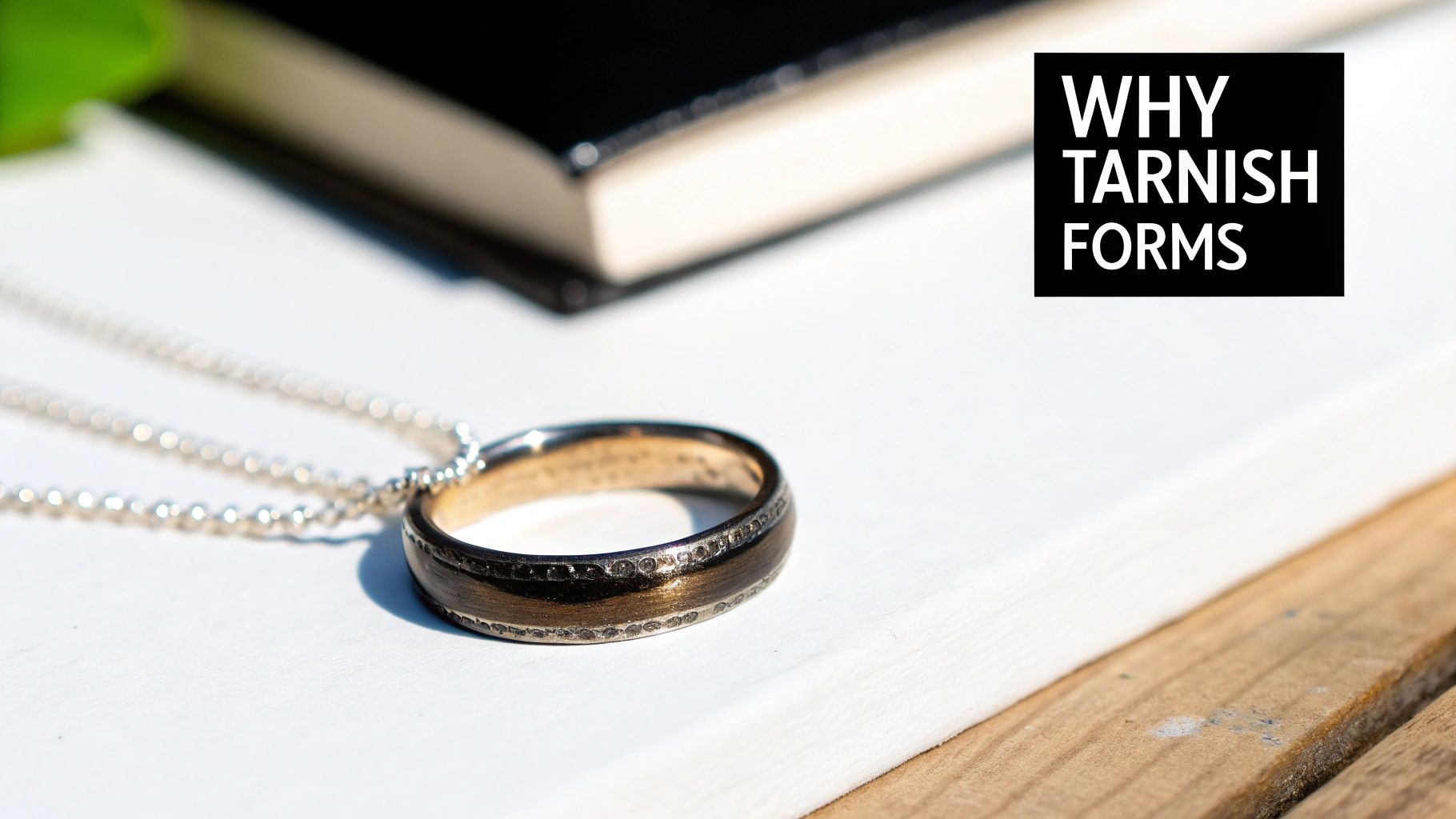 A tarnished sterling silver ring on a dark surface, showing dullness and dark spots.