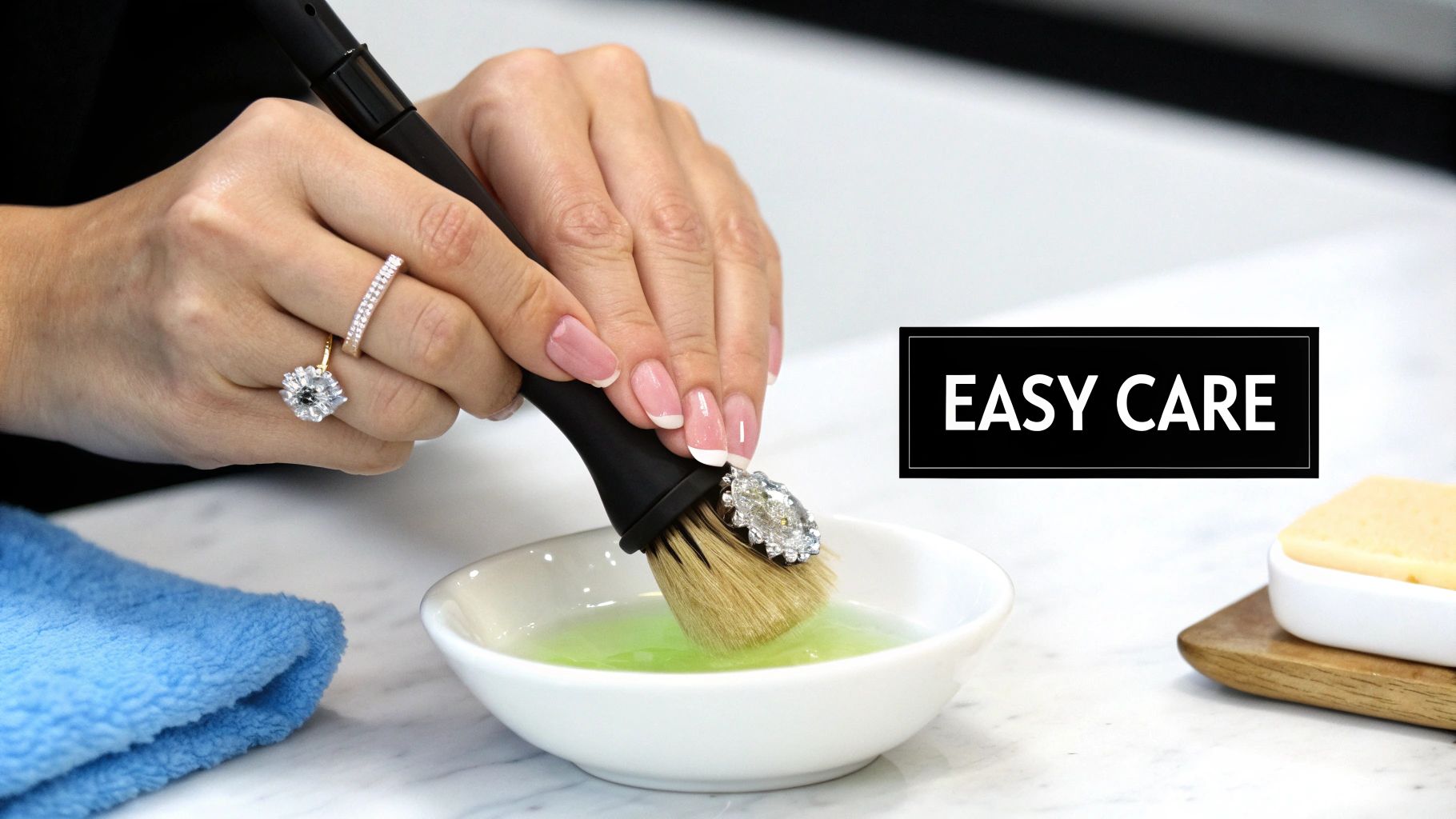 A close-up of a sparkling moissanite ring resting on a textured white surface.