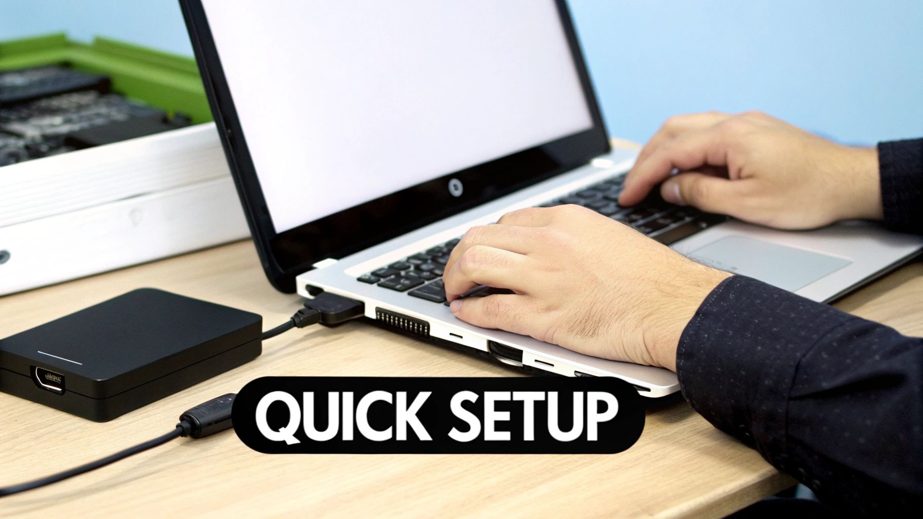 A person types on a laptop keyboard with an external black drive connected via a USB cable, showing quick setup.