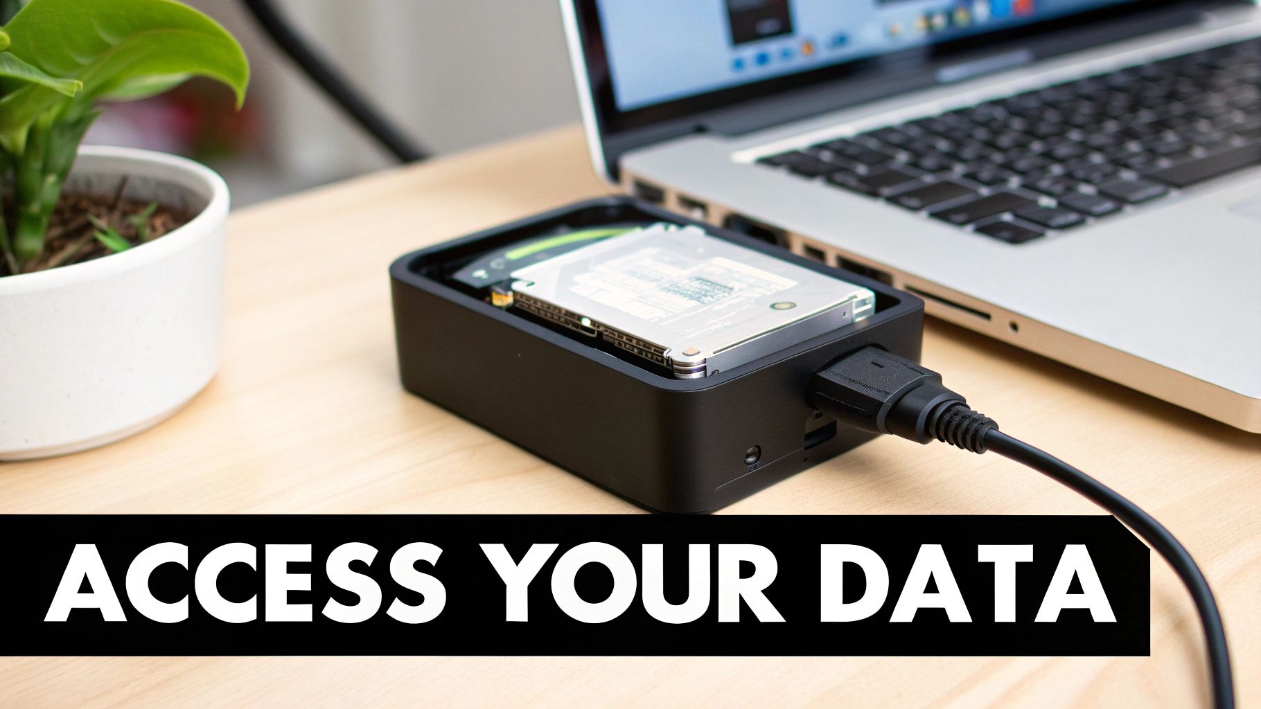 A portable hard drive docking station connected to a silver laptop for data access and backup.