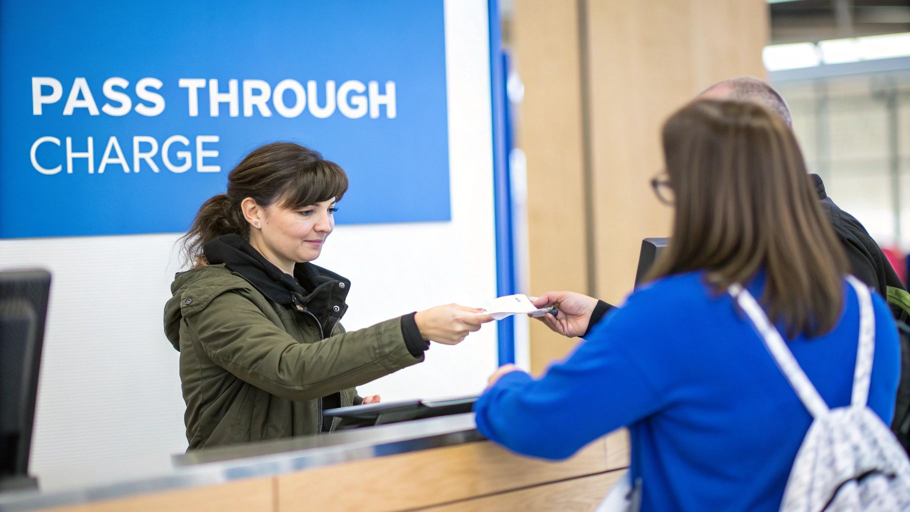 Customer handing document to service representative at pass through charge counter in blue uniform