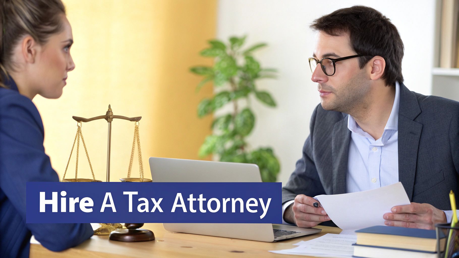 A man in glasses, likely a tax attorney, reviewing documents with a female client in an office.