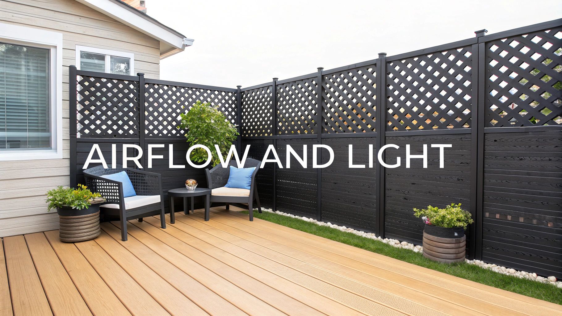 Outdoor deck with black lattice privacy fencing, plants, and modern patio seating.