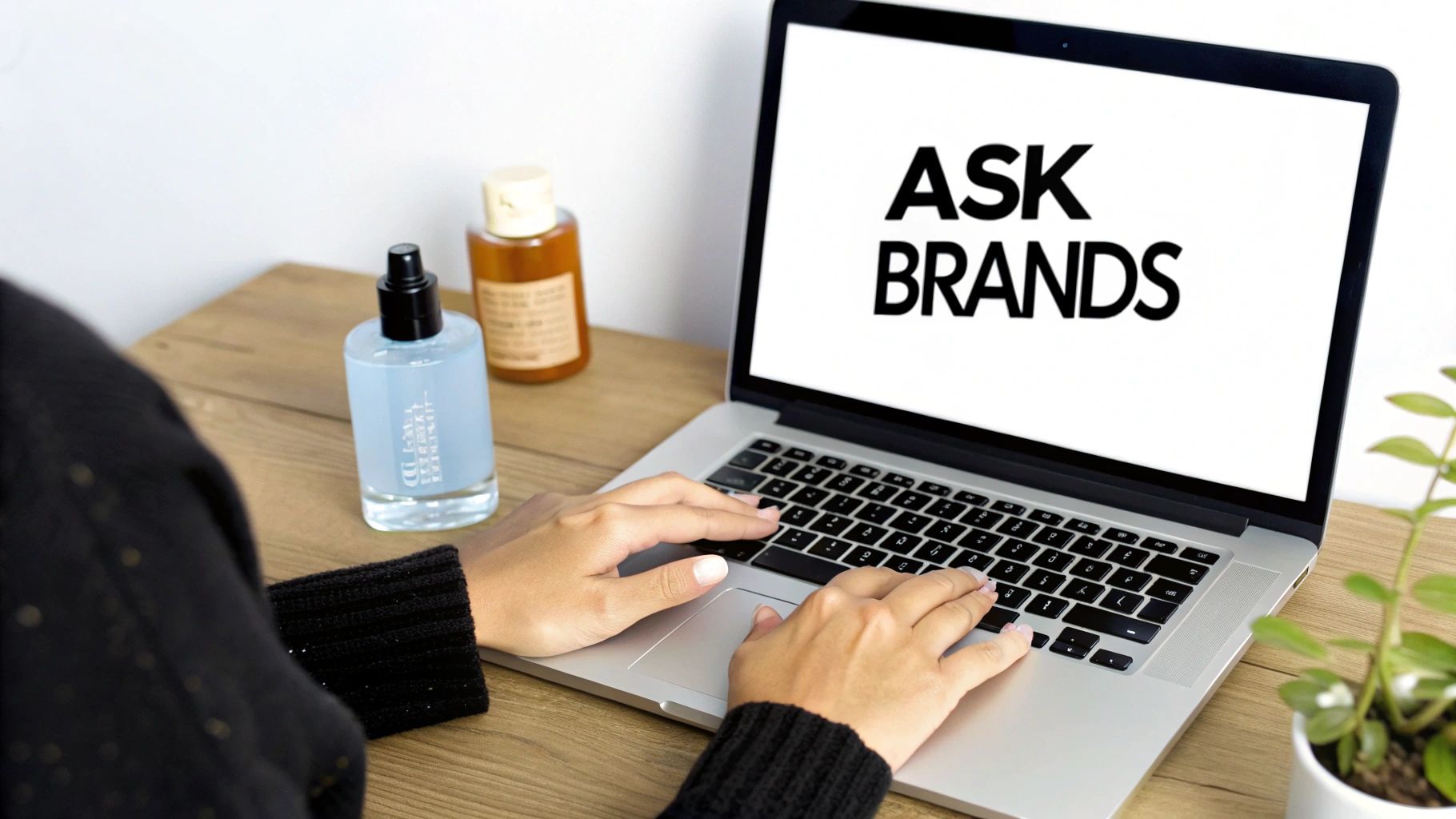 A person's hands typing a personalized email on a laptop, with a brand's product visible on the desk.