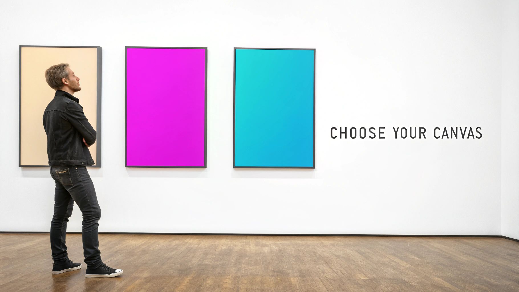 A man stands in a modern gallery, looking at three colorful blank canvases displayed on a white wall.