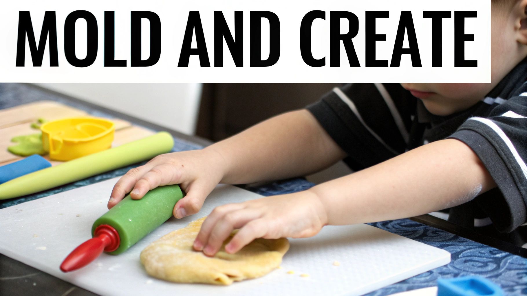 A child's hands use a green rolling pin to flatten dough or play-doh, engaged in creative activity.