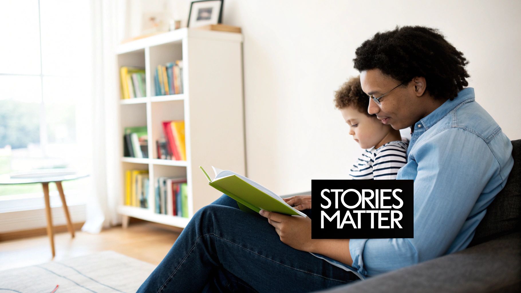A father and young child read a green book together on a couch, with a bookshelf behind them.