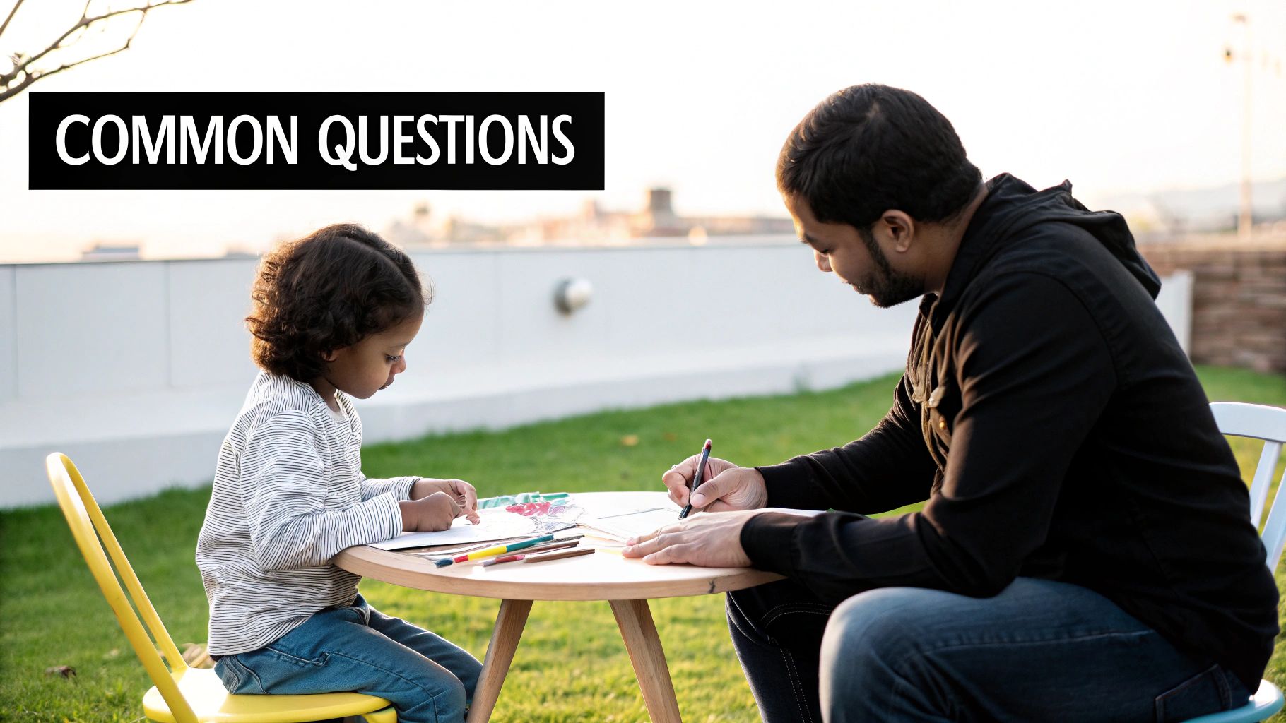 Father and young child drawing together outdoors at table discussing feelings and emotions