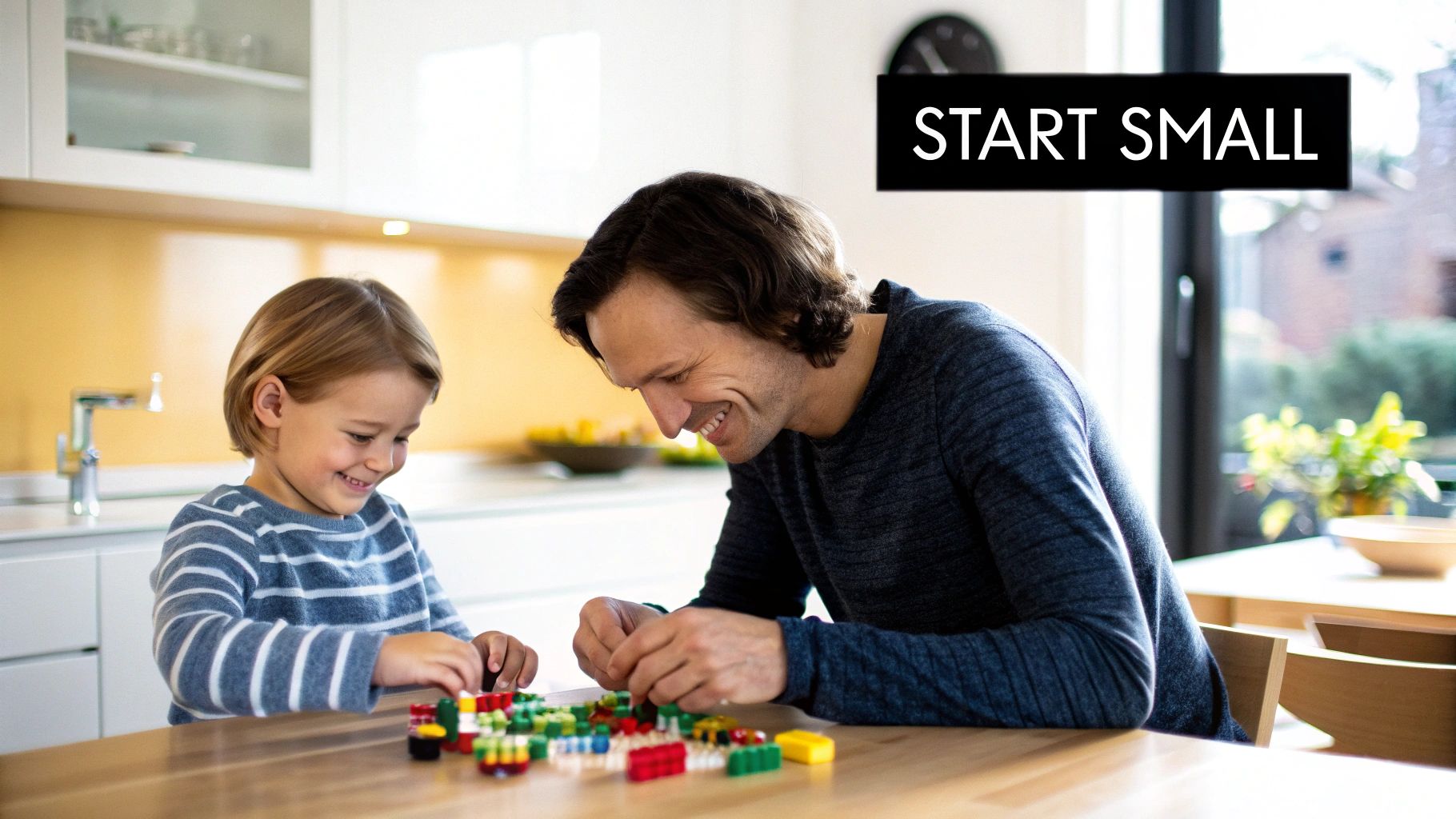 Happy father and child building with colorful toy blocks together in a bright kitchen.